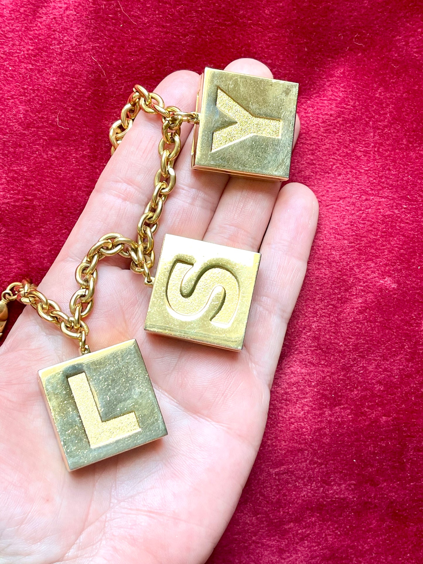 On hand YSL charms Yves Saint Laurent vintage 2000 makeup bracelet very good condition on red velvet background