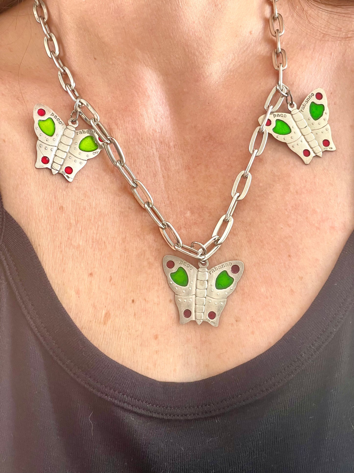 Front view of necklace showing engraved Paco Rabanne markings on each butterfly charm worn by model