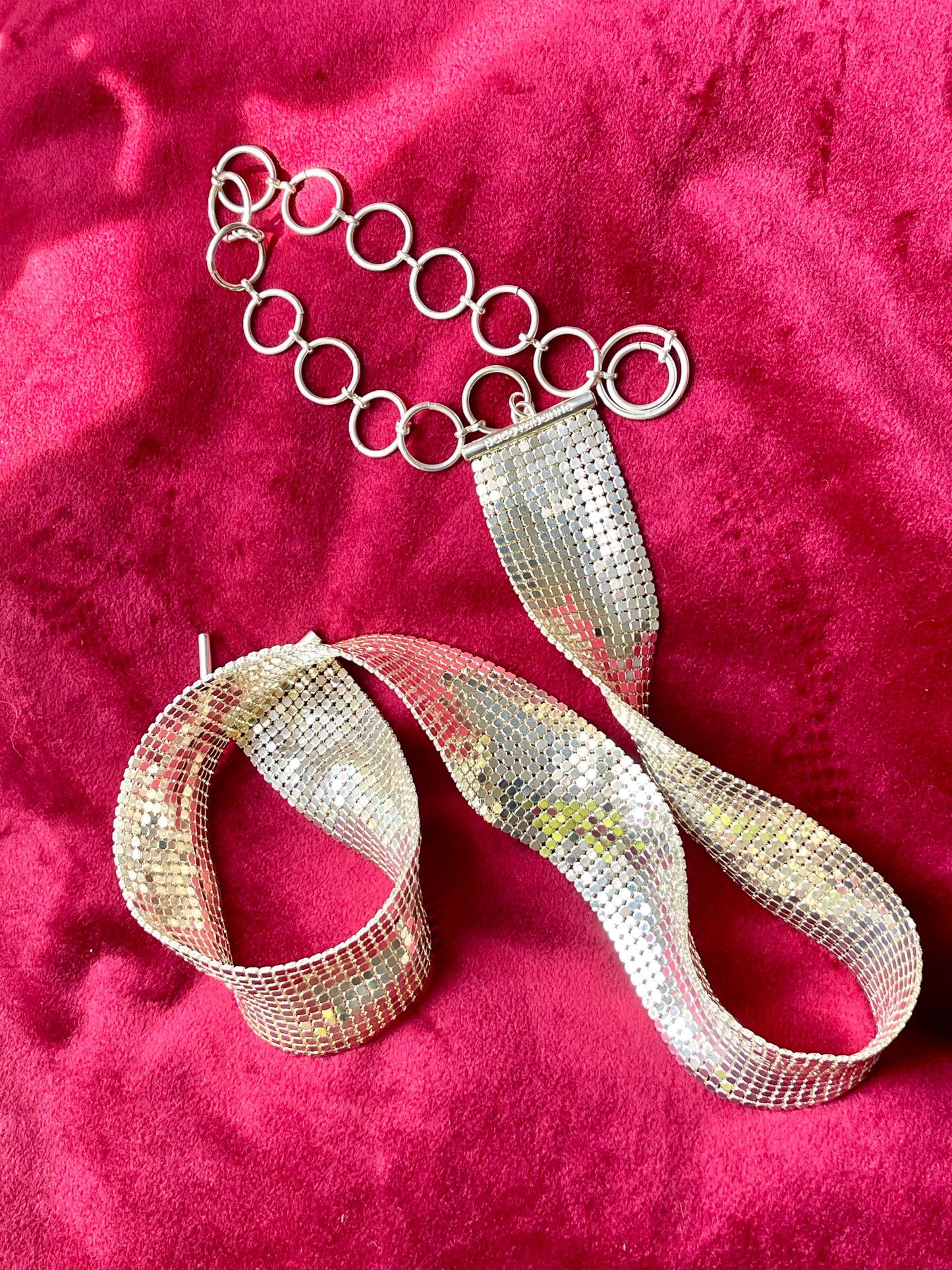 vintage silver Paco Rabanne mesh belt on red velvet background showing the whole view of mesh pixels and hoops