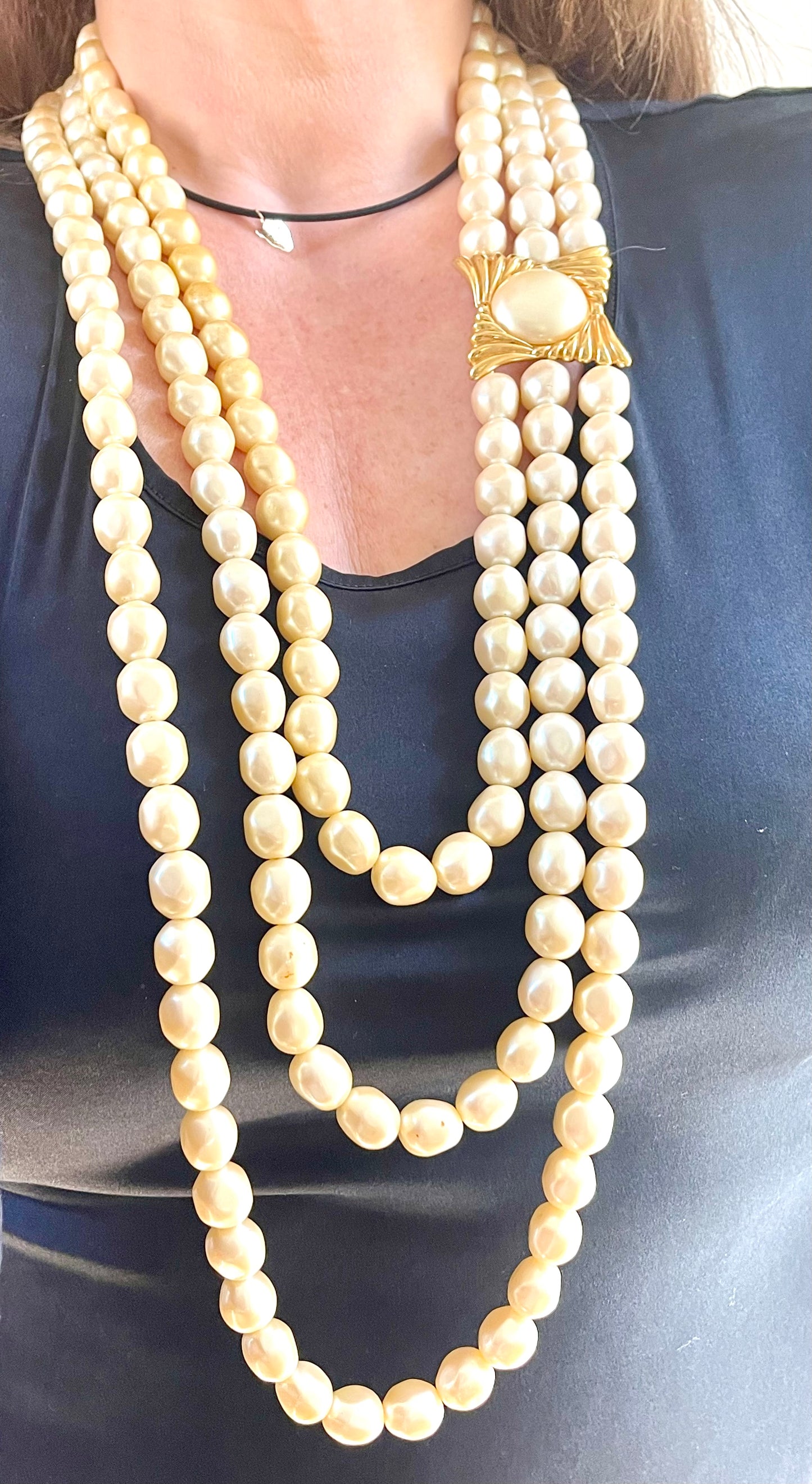 Vintage Yves Saint Laurent faux pearl statement necklace worn on model, showcasing multi-strand design and bold gold clasp at the neckline.