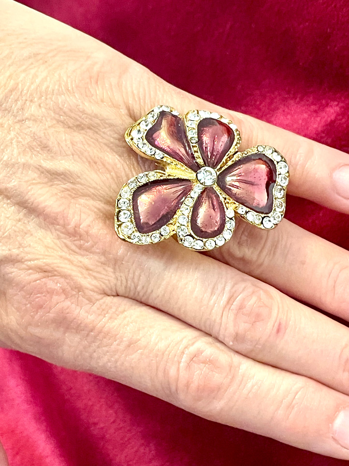 Rare authentic Yves Saint Laurent vintage floral ring on hand, featuring metallic pink enamel petals and crystal accents