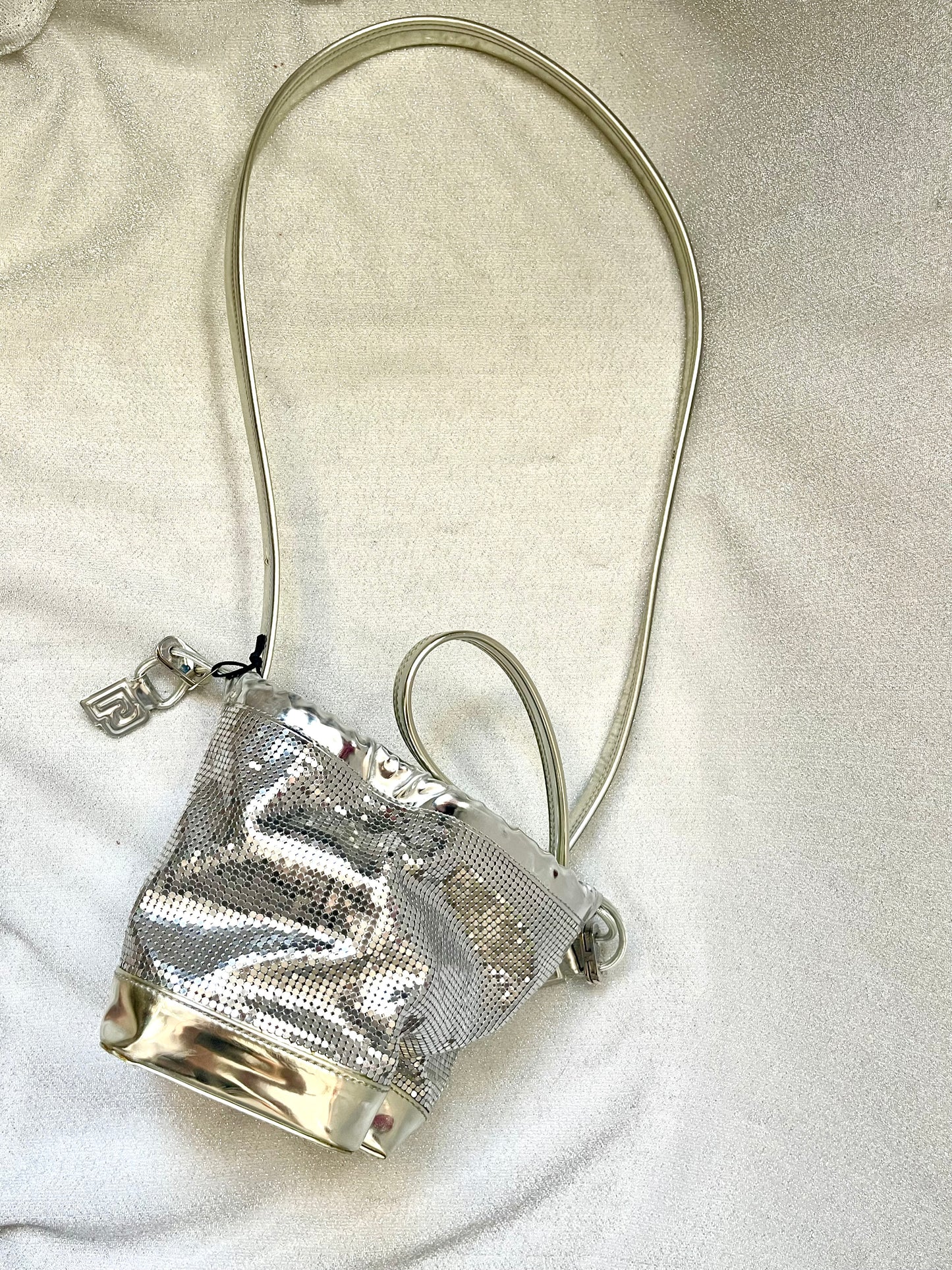 Top view of Paco Rabanne pixel silver vinyl leather bag with structured top flap showing embossed ‘R’ logo and metallic finish.