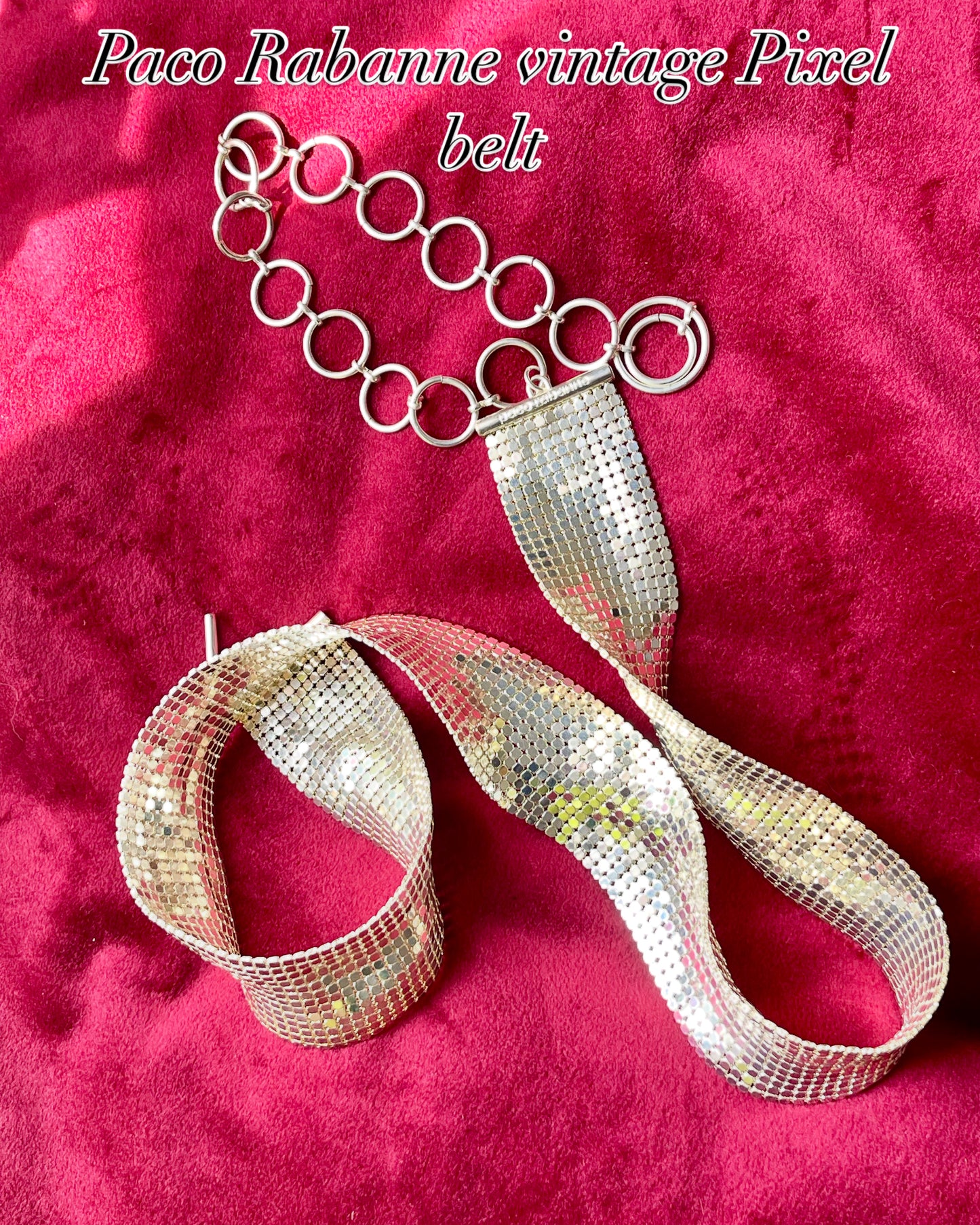 Upper view vintage silver Paco Rabanne mesh belt on red velvet background.