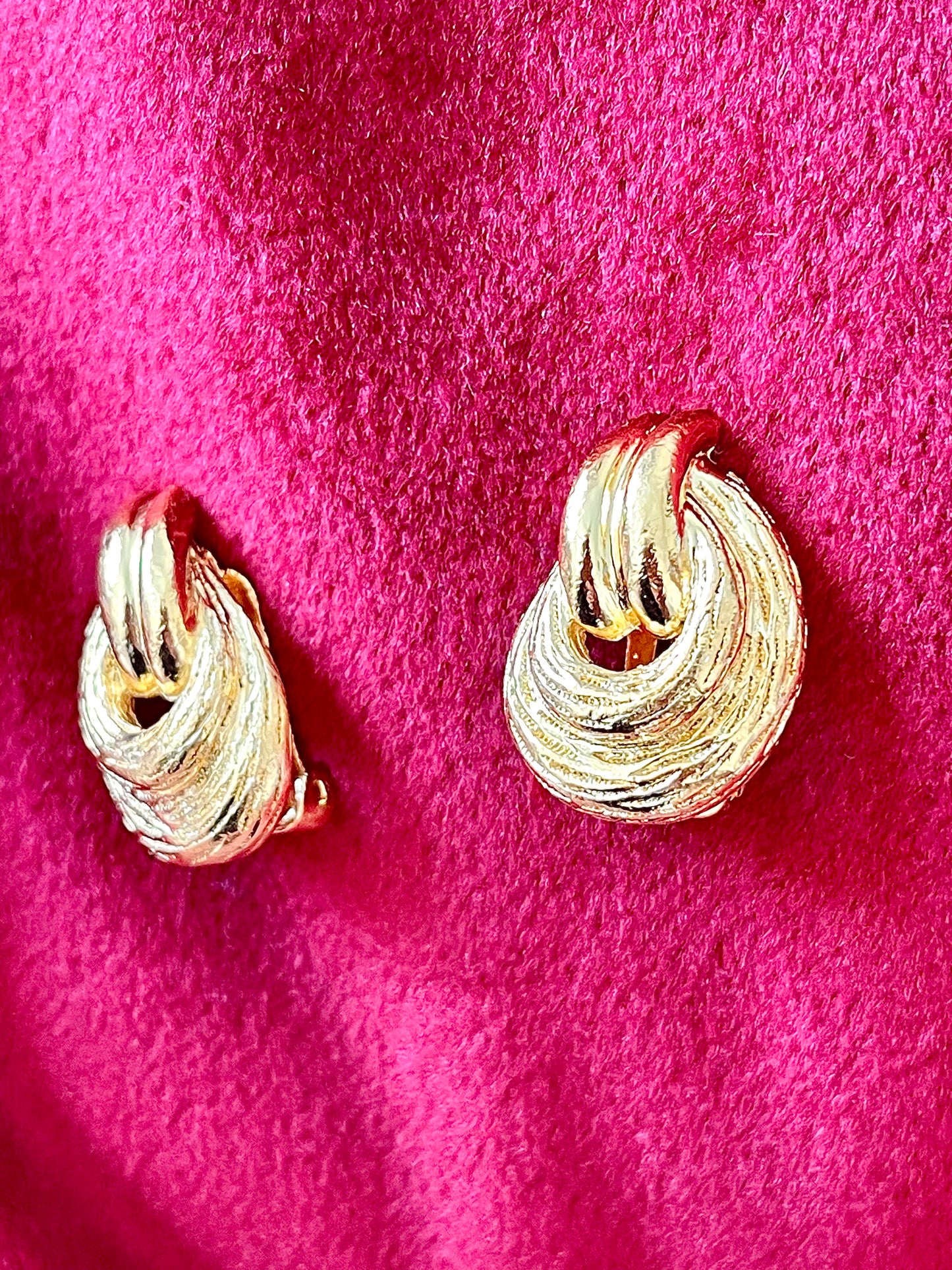 Side view Vintage Christian Dior clip on Dior earrings, gold plated 18KG displayed on a red velvet background