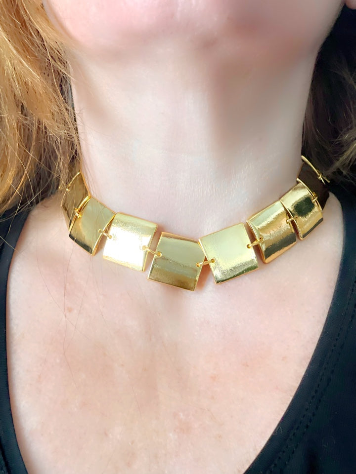Close up on necklace worn by model , cubic design Iconic Paco Rabanne vintage gold plated jewelry set , bracelet- necklace refurbished 18KG