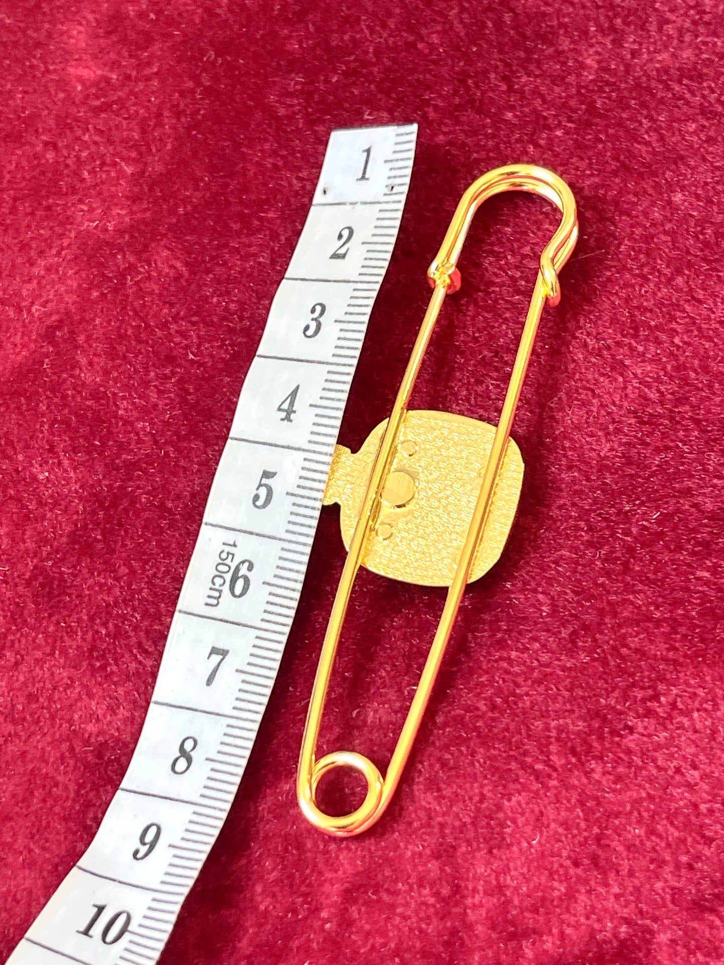 Back view showing measurements of Rare Christian Dior Dune brooch vintage pin design, gold plated 18KG on a red velvet background using measuring tape