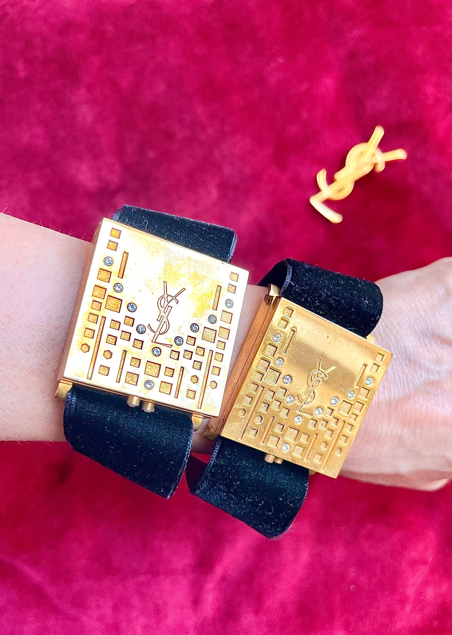 On hand worn by model two Fashion Bracelet makeup Yves Saint Laurent vintage 2000 displayed with YSL pins on a red velvet background