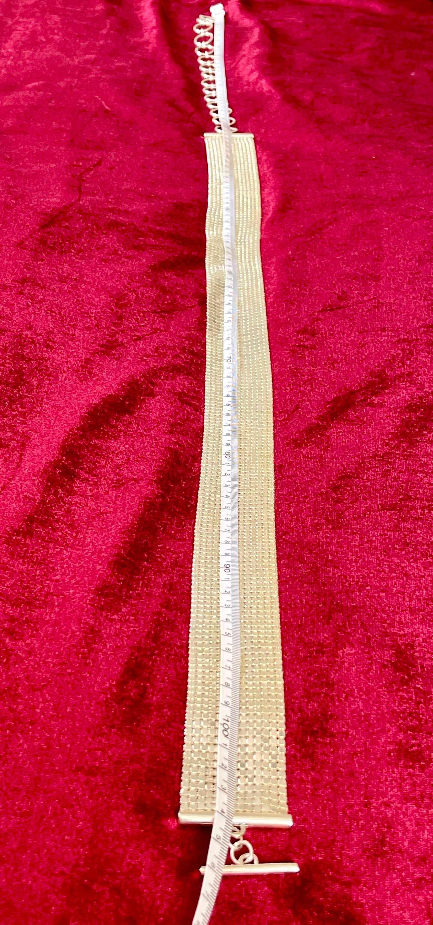 105cm length vintage silver Paco Rabanne mesh belt on red velvet background using a measuring tape