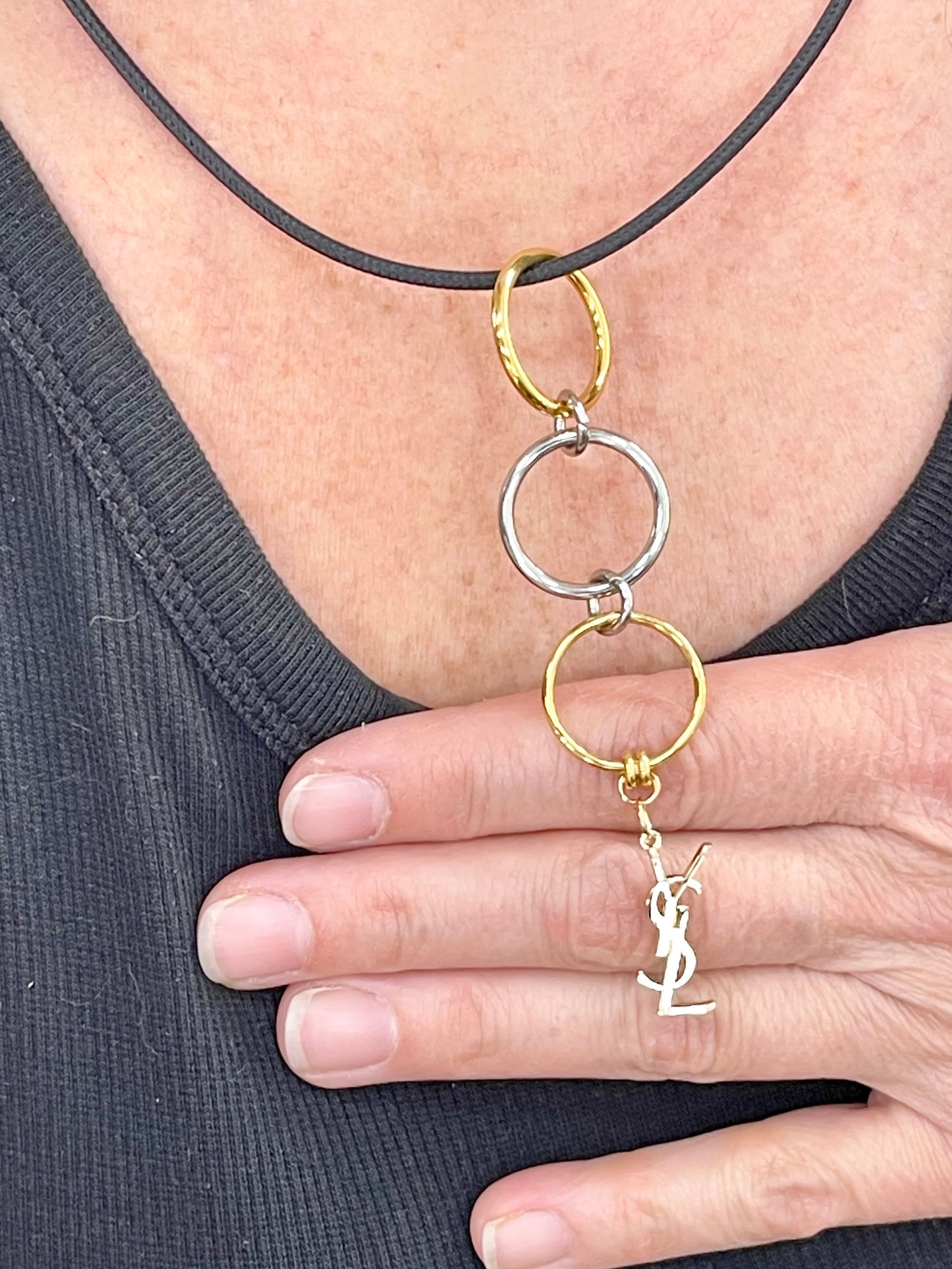 Close up view worn by model pendant necklace Yves Saint Laurent authentic charm as a pendant with magnetic black cord