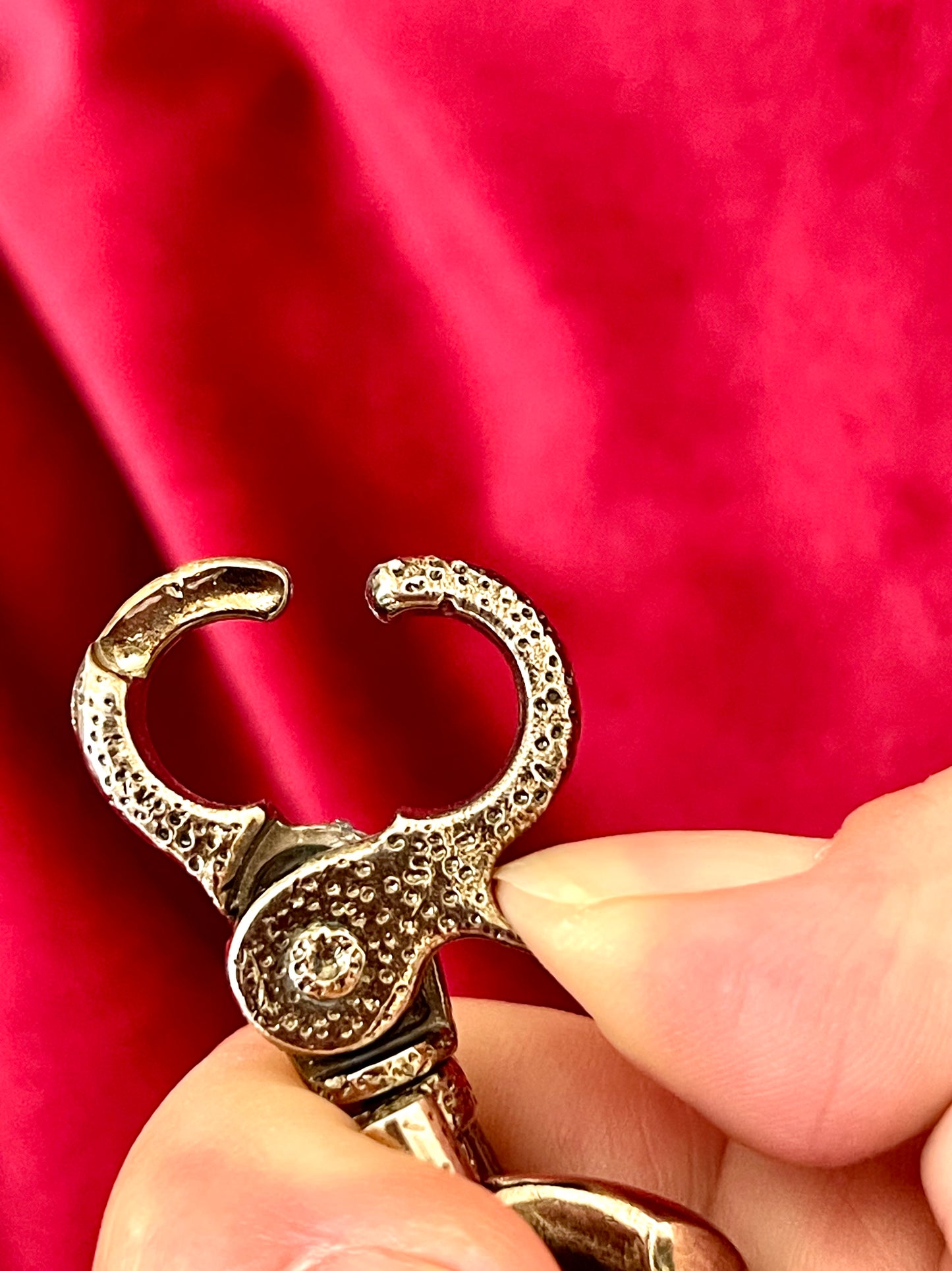 Buckle view close up Preloved YSL bronze and grey chain on a red red velvet vintage Yves Saint Laurent