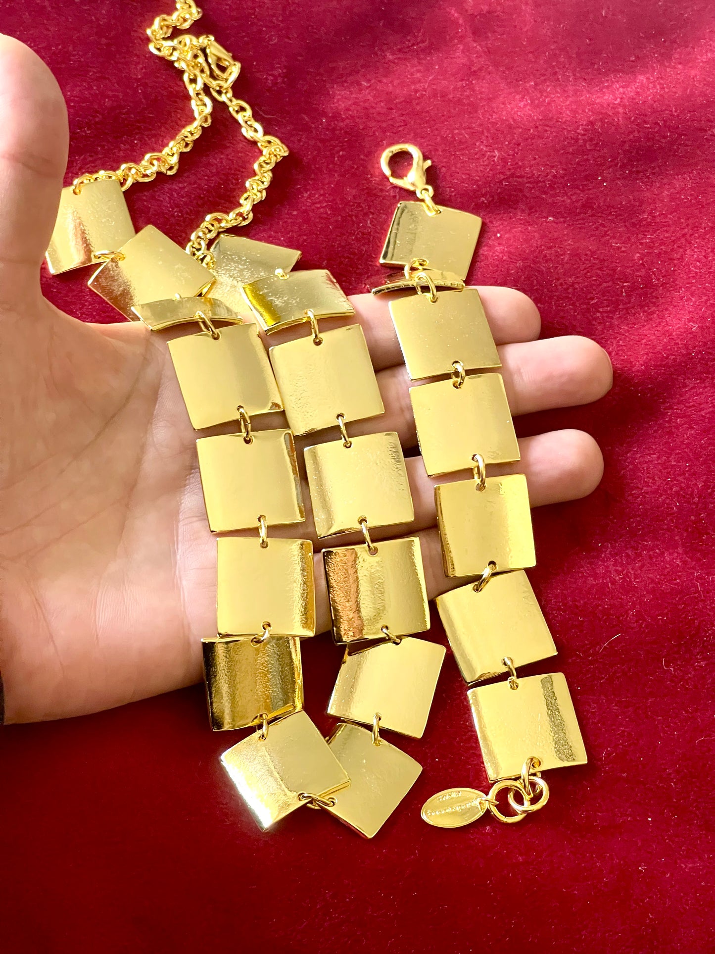 Close up details of gold tone on hand . Iconic Paco Rabanne vintage gold plated jewelry set , bracelet- necklace refurbished 18KG