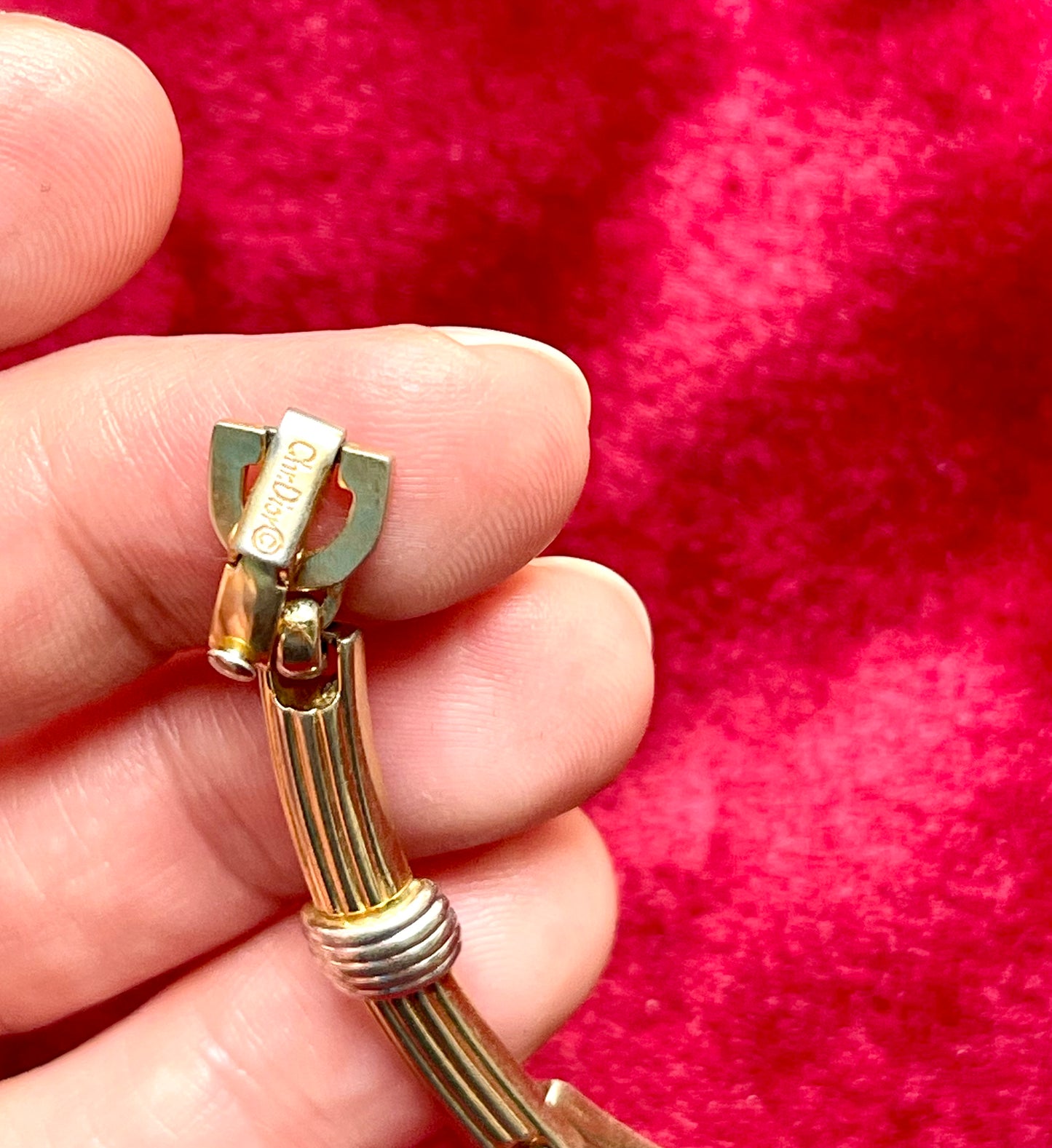Authentic signed Vintage Christian Dior two-tone necklace with ribbed accents displayed on a red velvet background