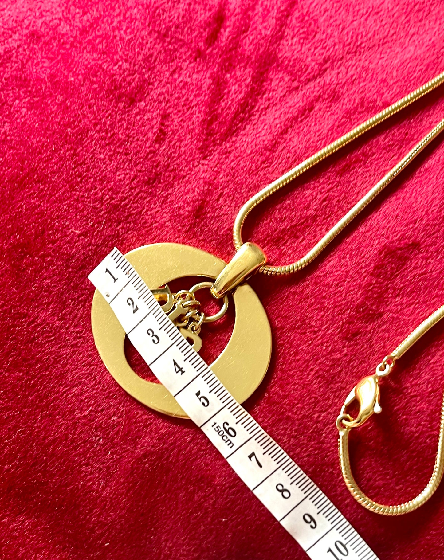 Detailed view of authentic 1990s–2000s Christian Dior logo necklace. Gold-tone finish, statement pendant.