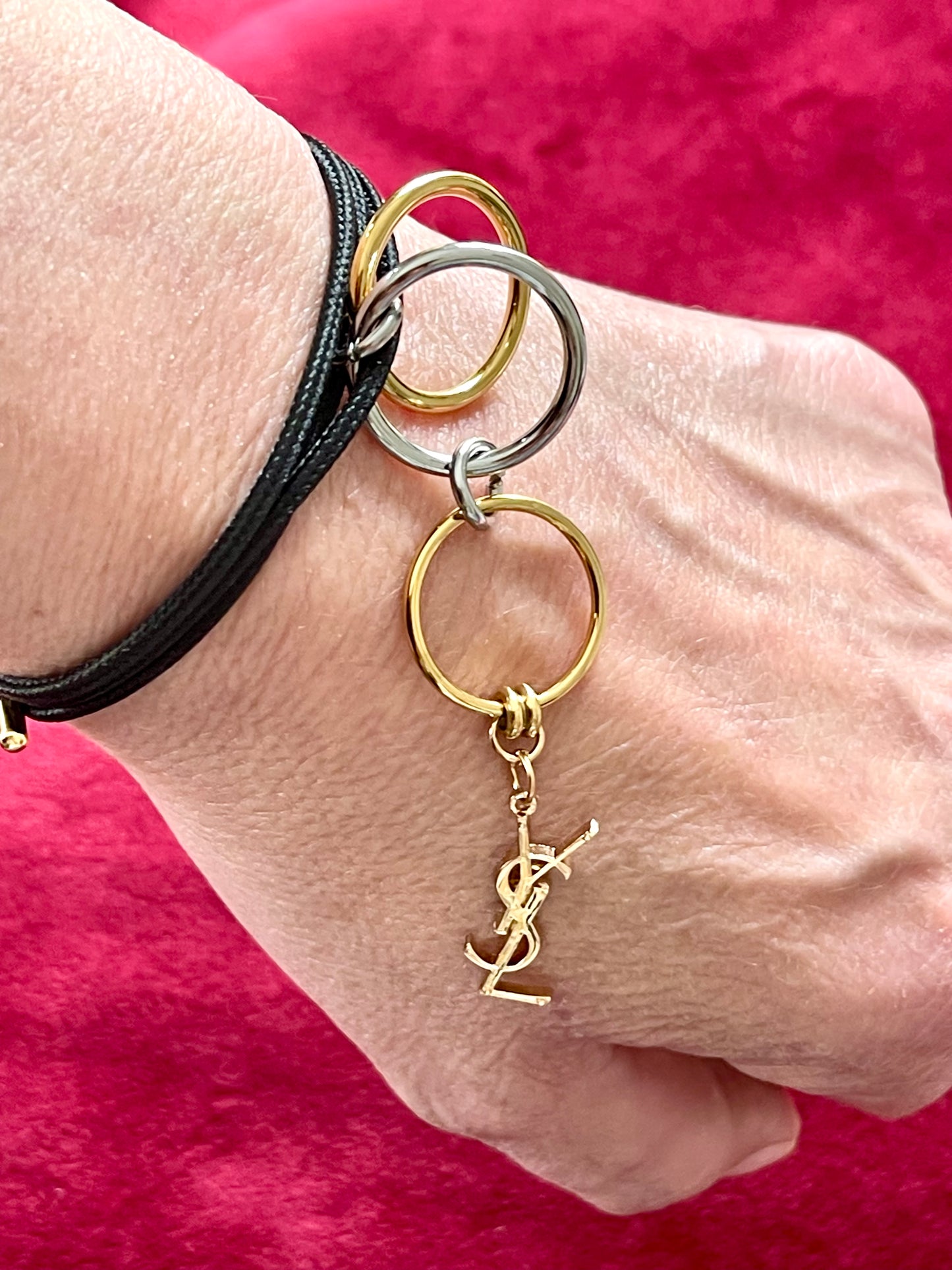 Worn as a charm bracelet Yves Saint Laurent authentic charm as a ring pendant and bracelet with magnetic black cord