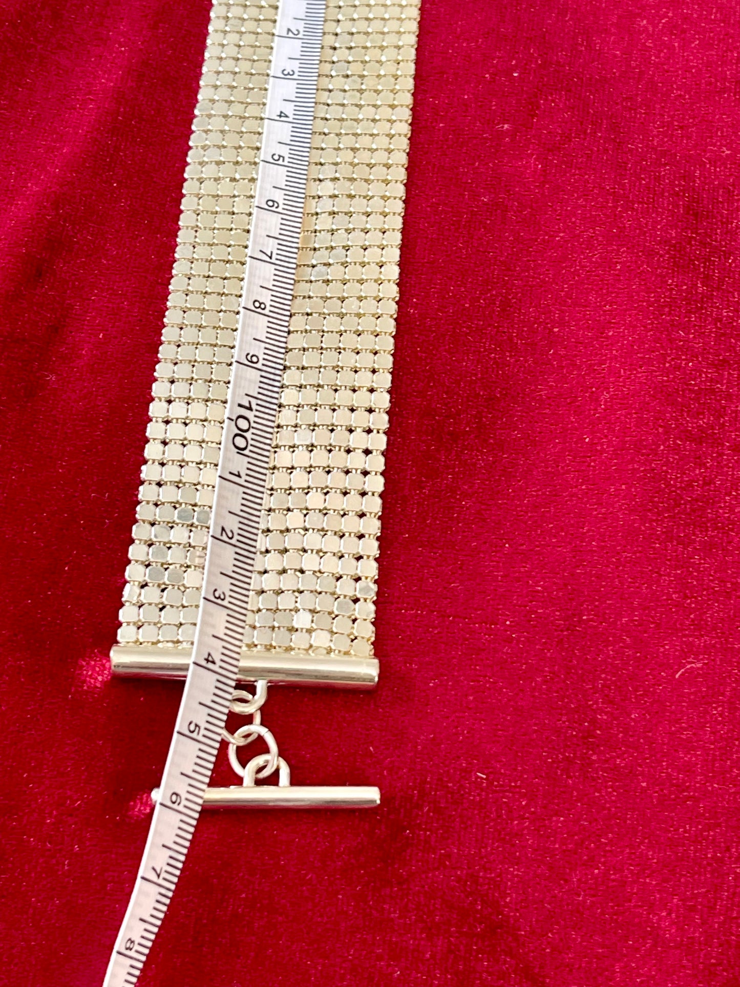 105cm length vintage silver Paco Rabanne mesh belt on red velvet background using a measuring tape