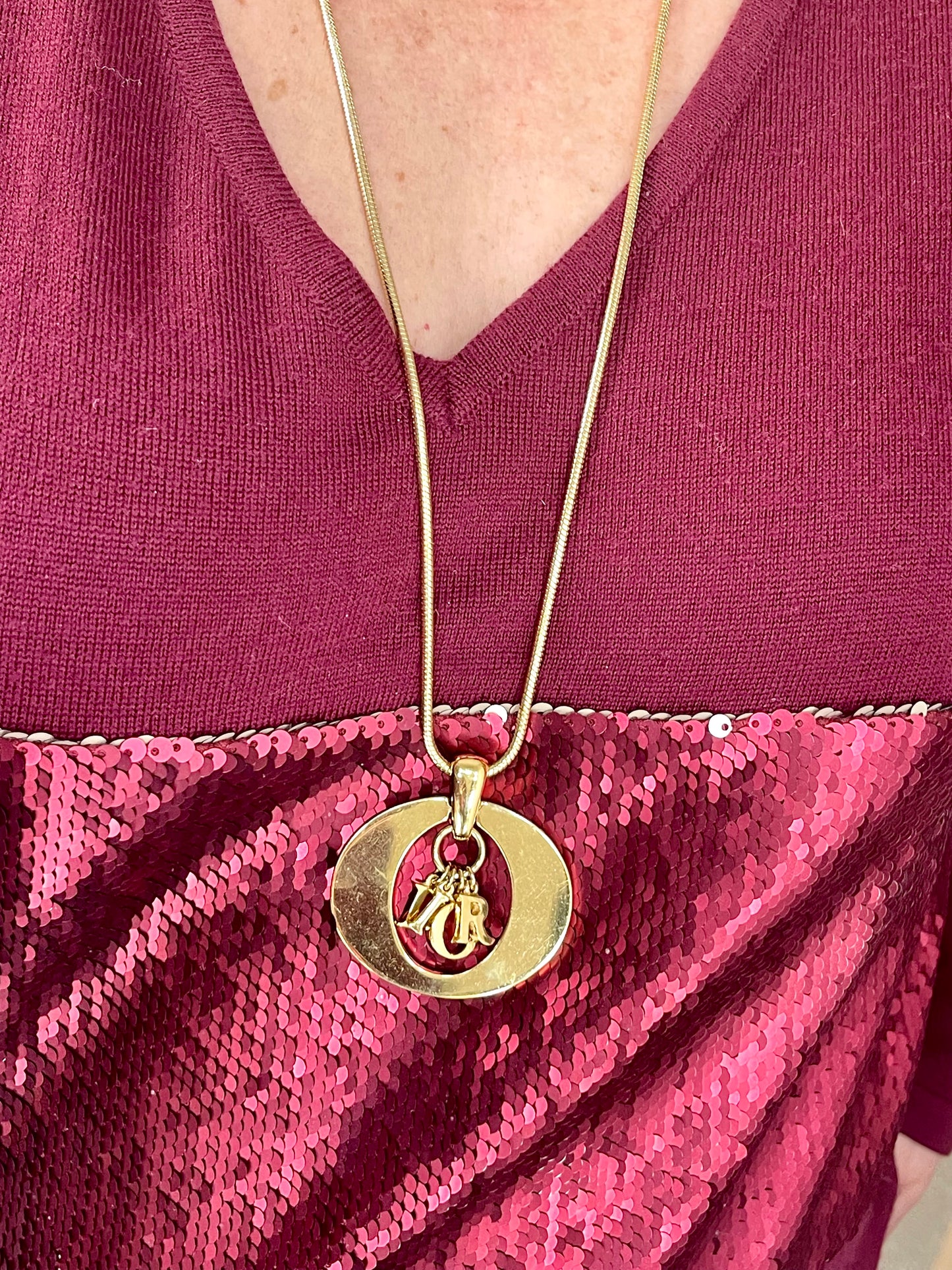 Vintage Christian Dior charm necklace in gold-tone metal, featuring bold logo pendant. Circa late 1990s.