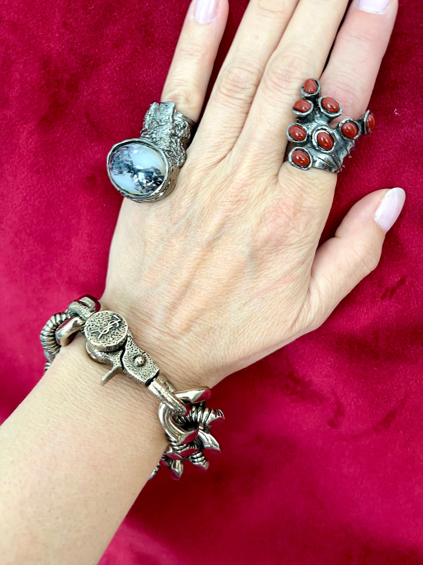 Worn by model Top view Preloved YSL bronze and grey chain worn as a statement piece with arty Yves Saint Laurent rings on a red velvet background