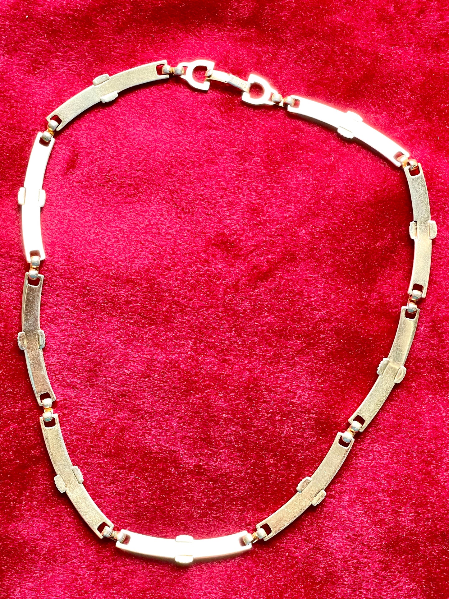 Back side Vintage Christian Dior two-tone necklace with ribbed accents displayed on a red velvet background