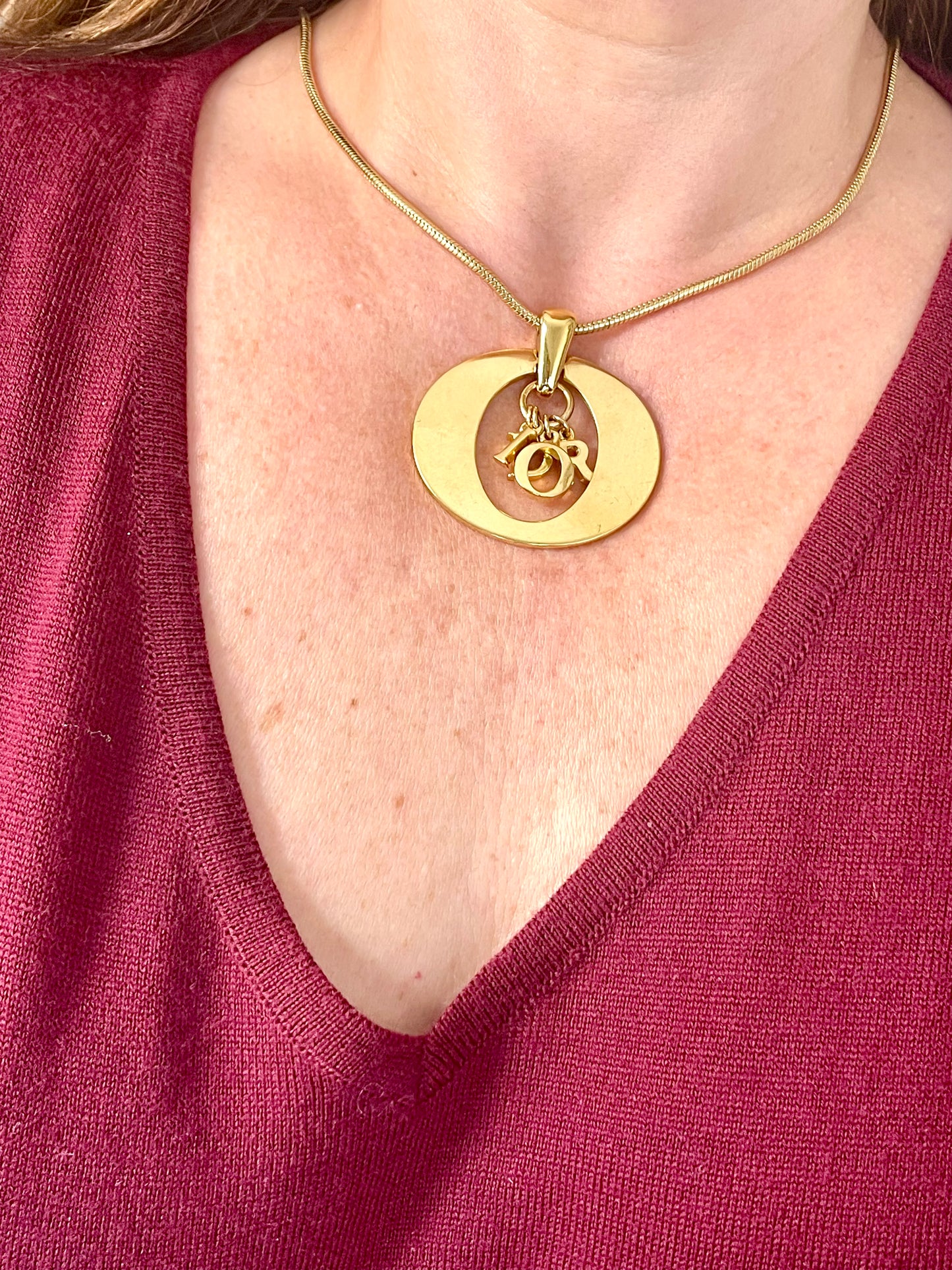 Close-up of vintage Dior gold-tone pendant necklace with hanging DIOR letter charms. Y2K fashion, approx. 46 cm.