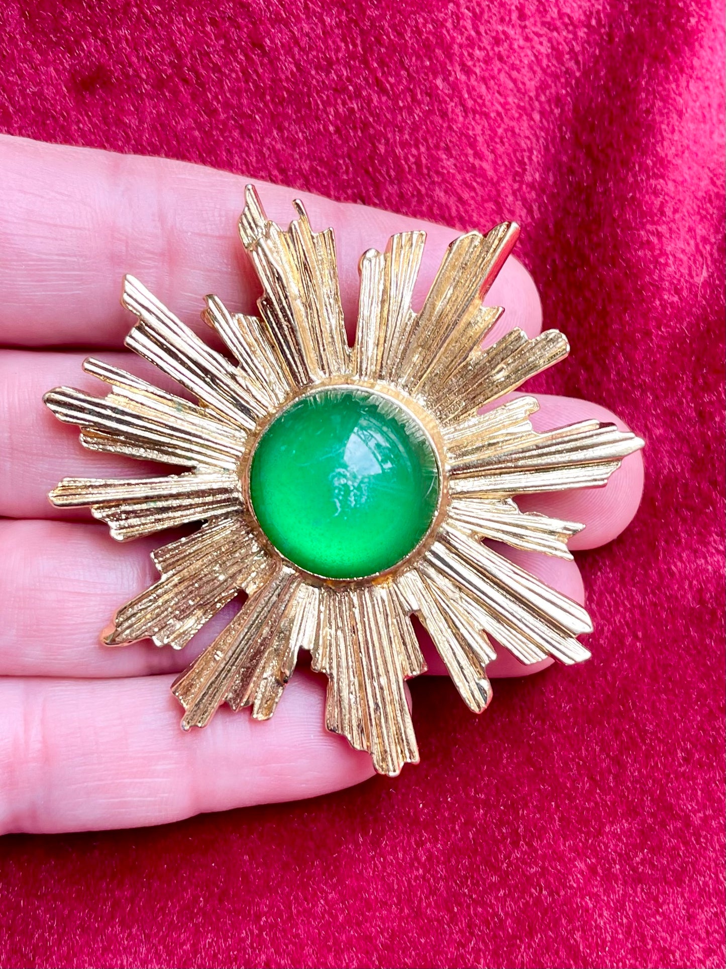 On hand authentic rare Vintage Yves Saint Laurent 1980s gold-tone sunburst brooch with green cabochon center