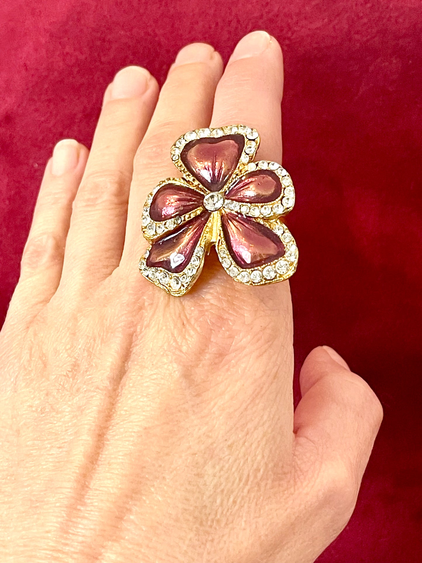 Rare Yves Saint Laurent vintage floral ring on hand, featuring metallic pink enamel petals and crystal accents
