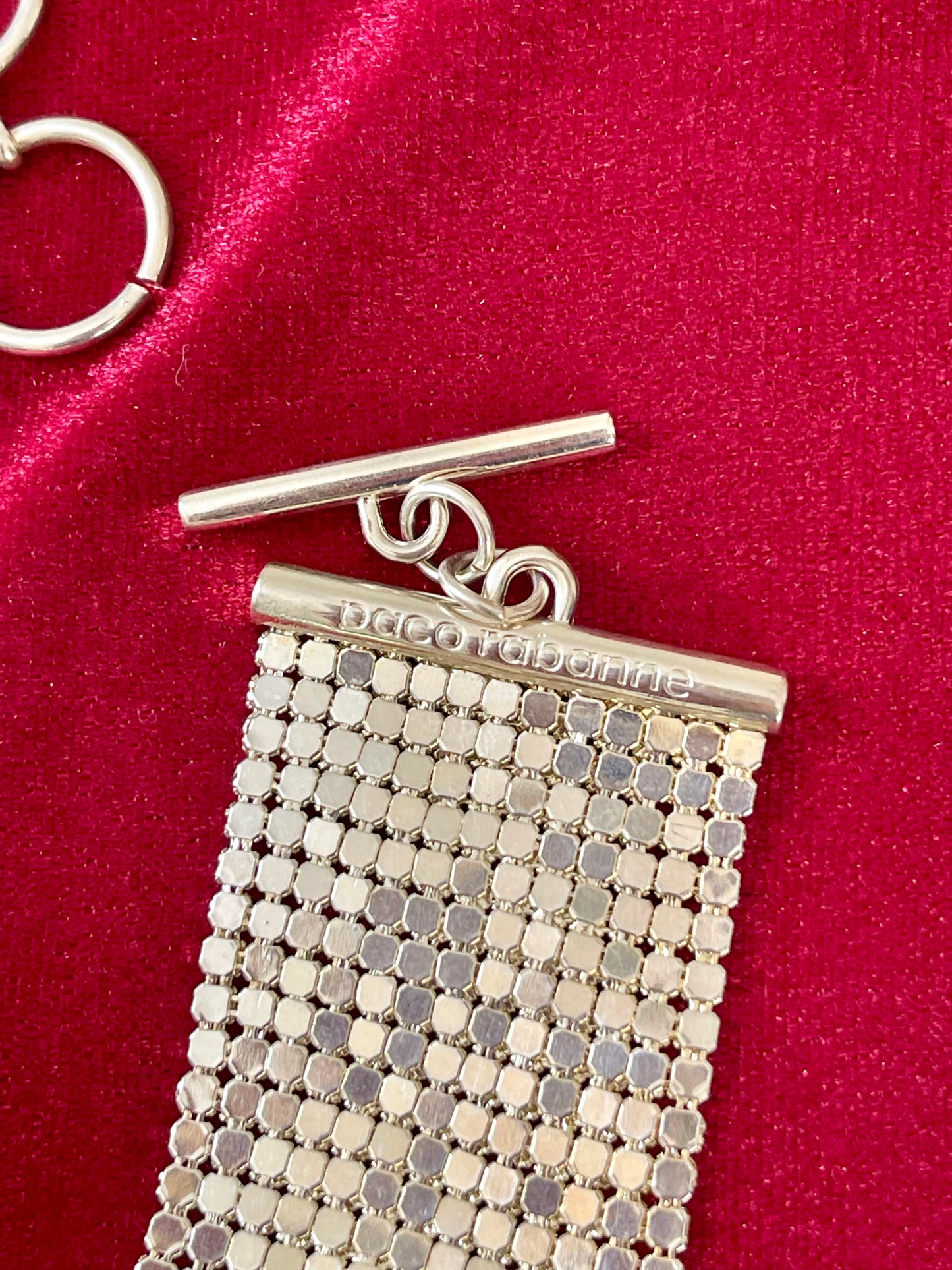 Close-up on signature of pixel metal mesh texture reflecting light of Vintage Paco Rabanne belt