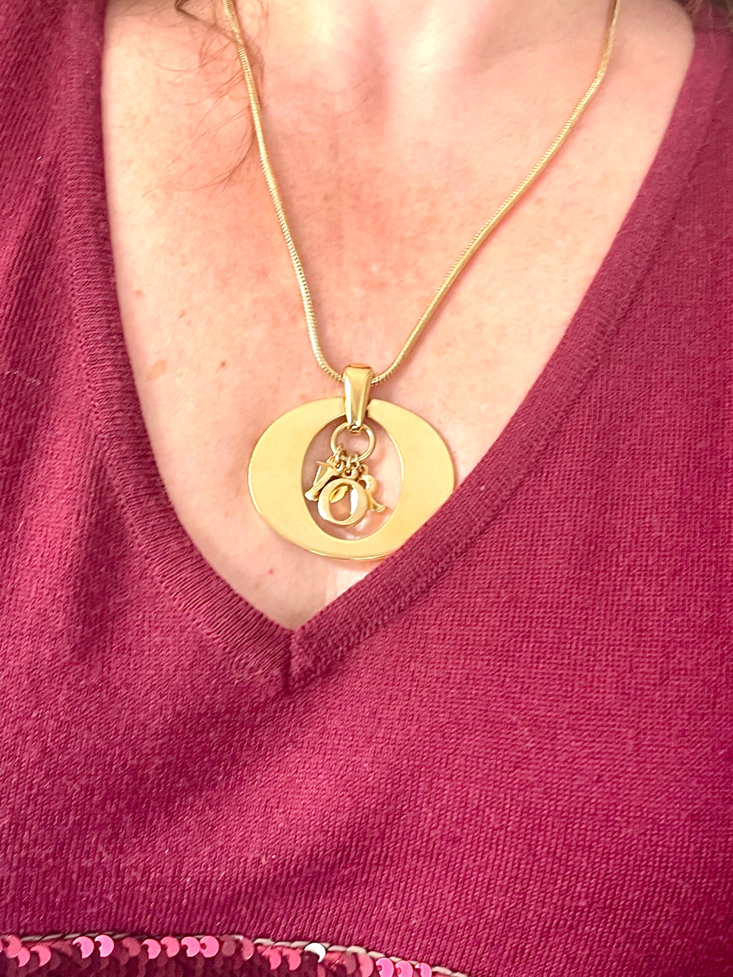 Close-up of vintage Dior gold-tone pendant necklace with hanging DIOR letter charms. Y2K fashion, approx. 46 cm.