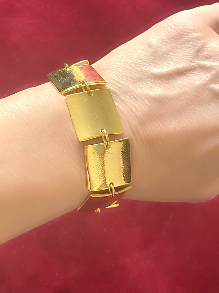 Close up of Iconic Paco Rabanne vintage gold plated jewelry set, cubic bracelet refurbished 18KG worn on model