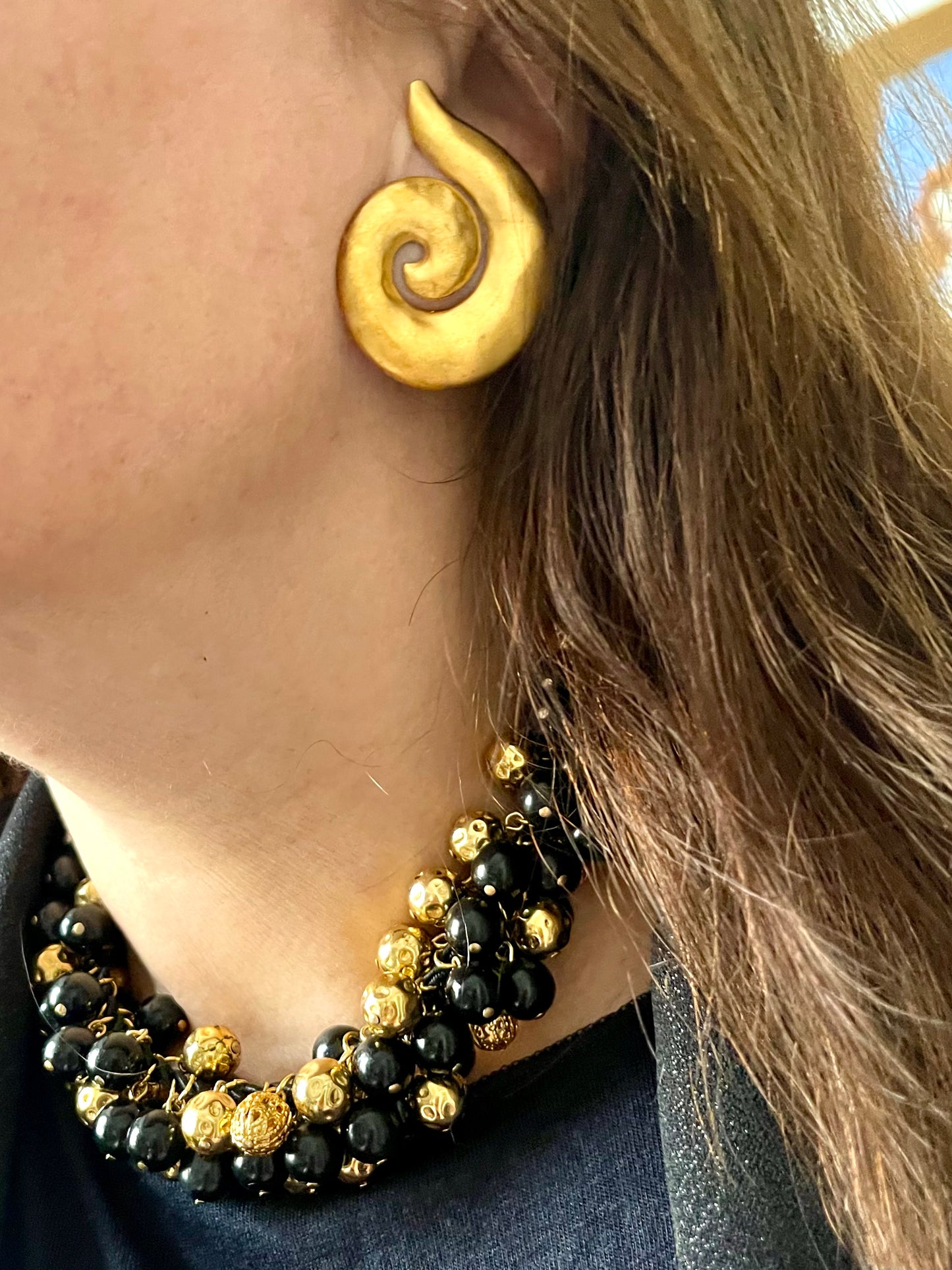Worn with spiral Yves Saint Laurent Earrings Vintage Yves Saint Laurent beaded necklace with black and gold beads, woven into braided black cotton cords, displayed on a black outfit worn by model