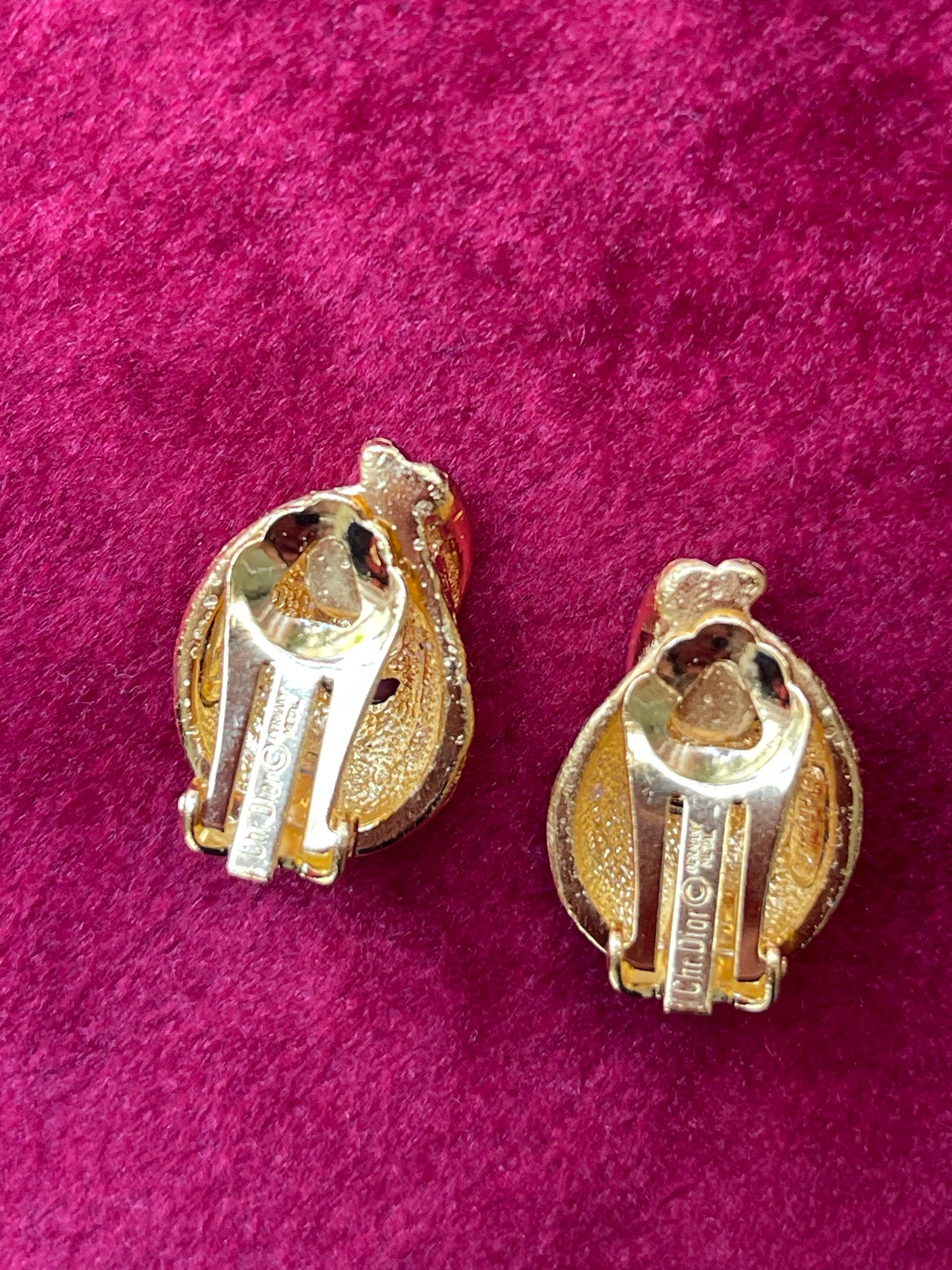 Back view signed clip on earrings Vintage Christian Dior -Dior refurbished earrings, gold plated 18KG displayed on a red velvet background