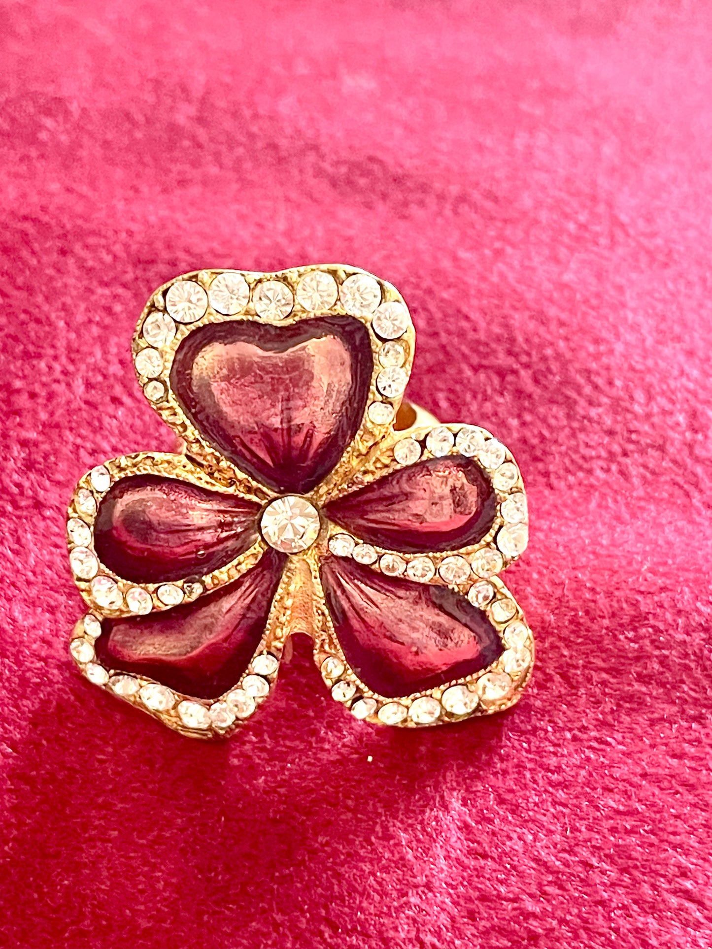 Close-up of YSL gold-tone flower ring with rhinestones and pink enamel detail