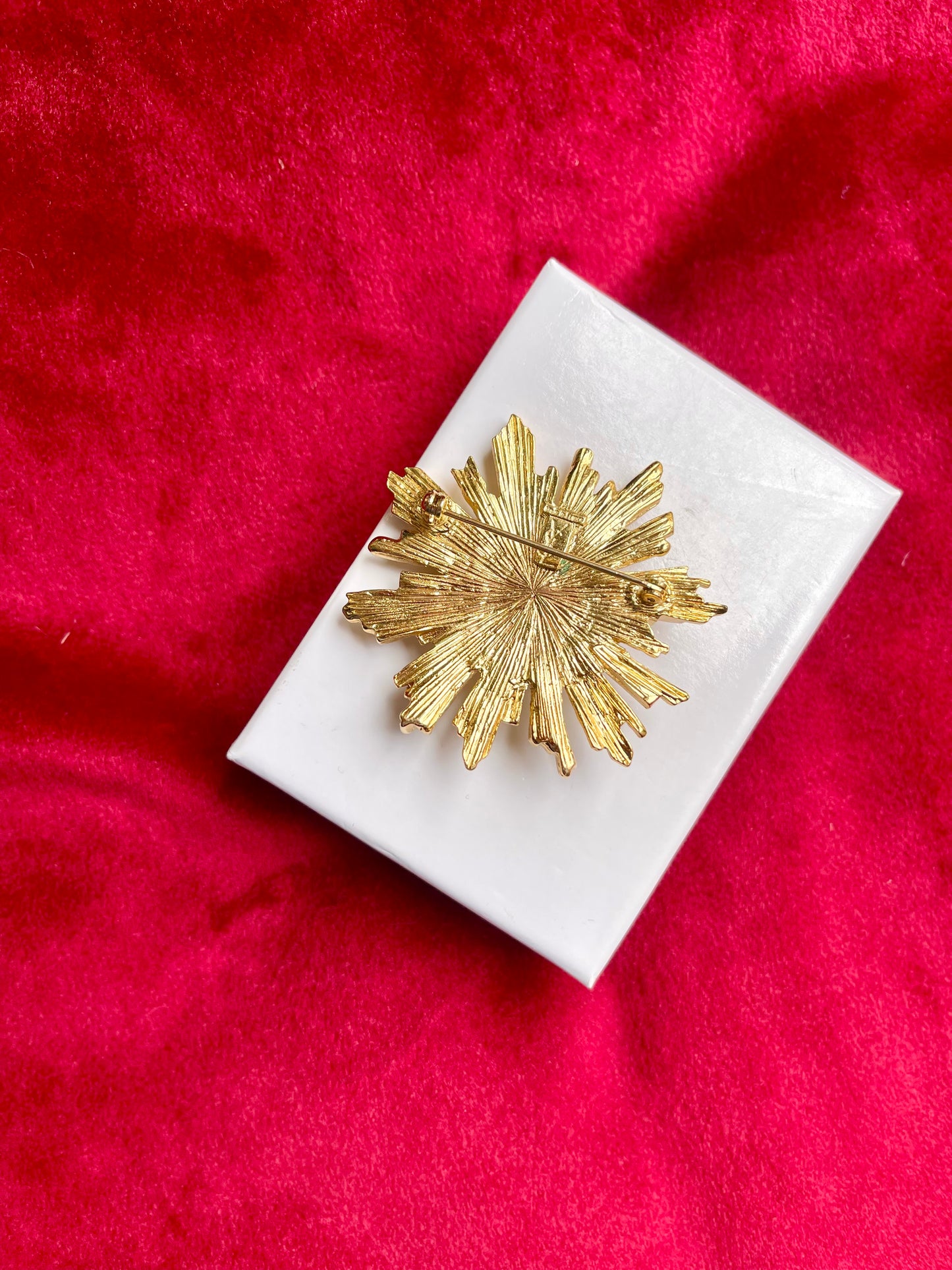 Back view Authentic signed Vintage Yves Saint Laurent 1980s gold-tone sunburst brooch with green cabochon center on white display