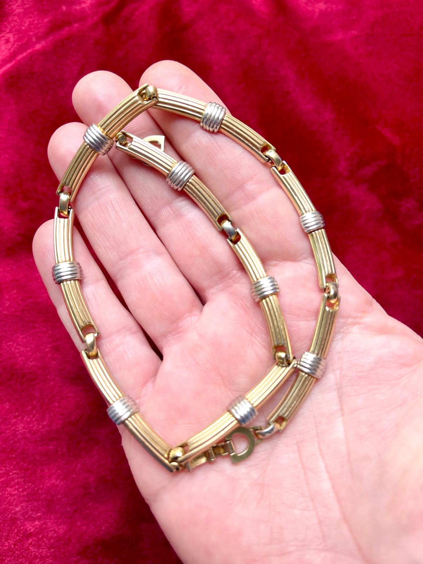 Skin tone Vintage Christian Dior two-tone necklace with ribbed accents displayed on a red velvet background