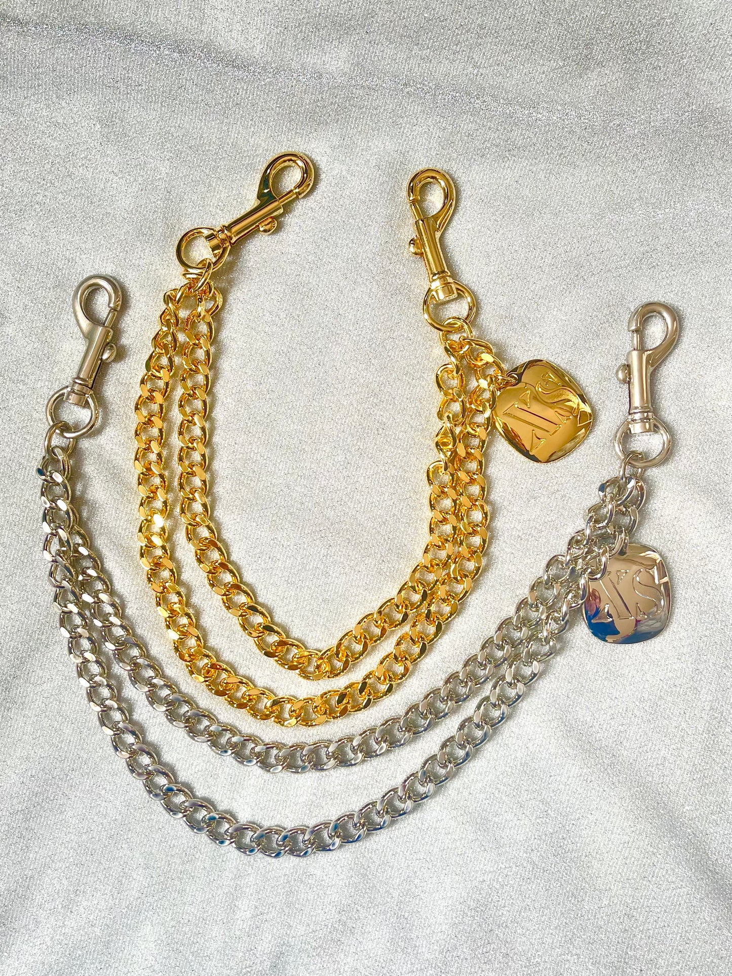 Top view Showing two tones of Original Paco Rabanne vintage Black XS perfume chain necklace displayed on a red velvet background