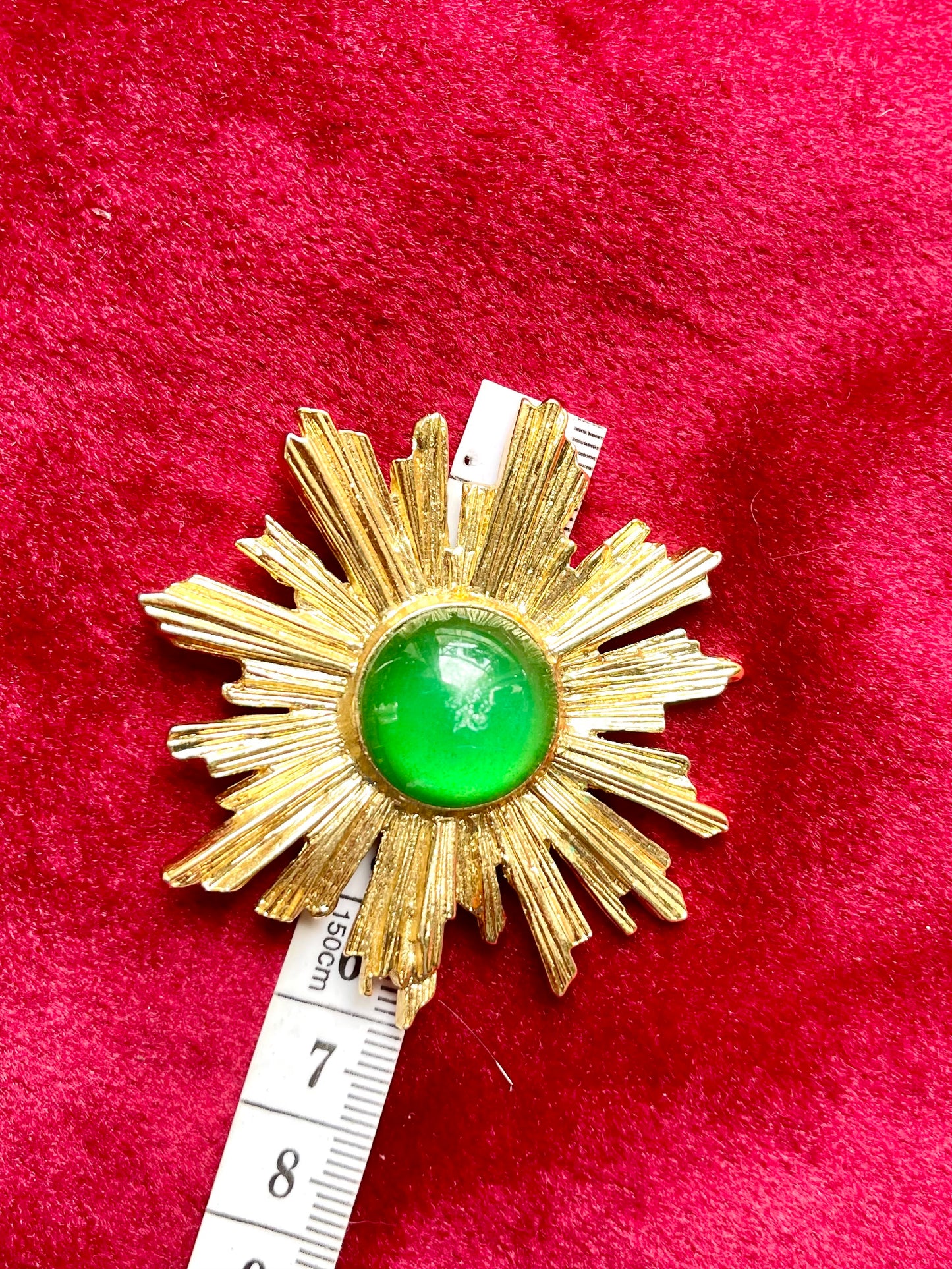 6 cm length and width Vintage Yves Saint Laurent 1980s gold-tone sunburst brooch with green cabochon center using a measuring tape