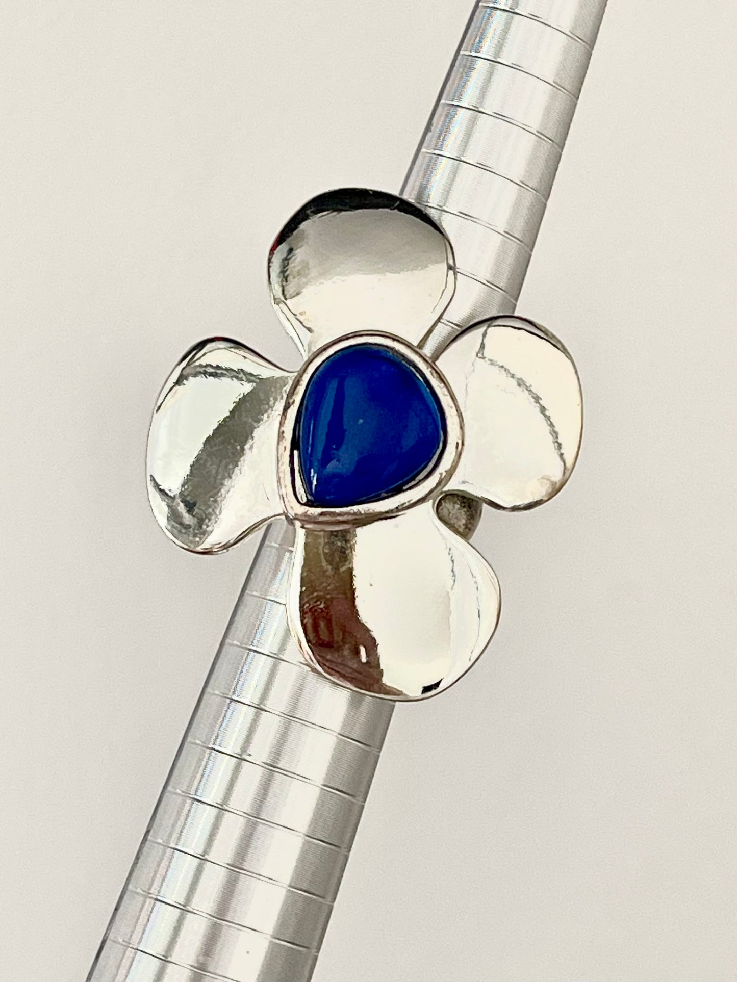 Front view of YSL vintage flower ring featuring a deep sea blue acrylic stone and silver-tone finish
