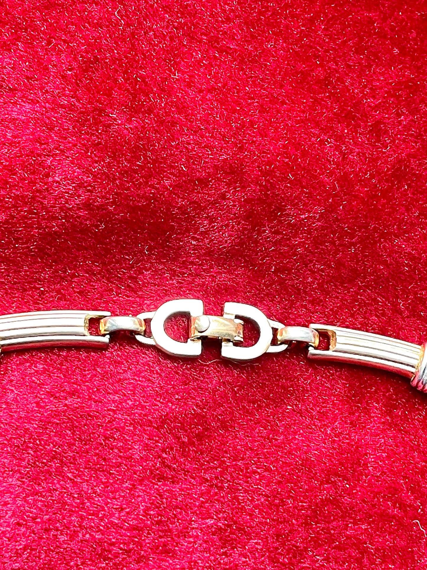 Lobster clasp signed Vintage Christian Dior two-tone necklace with ribbed accents displayed on a red velvet background