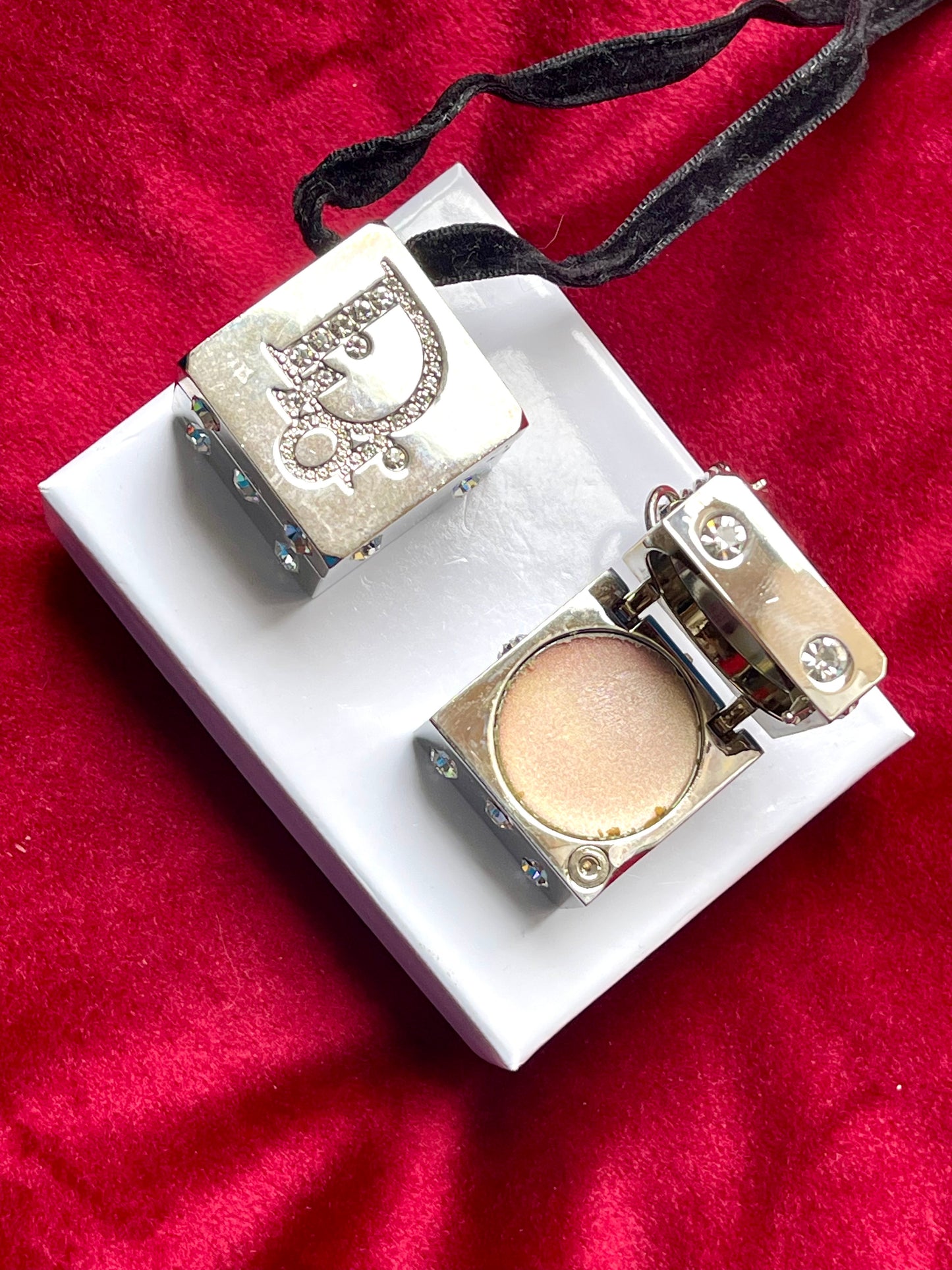 Side angle showing both compartments of the Dior Play dice charm, one open and one sealed