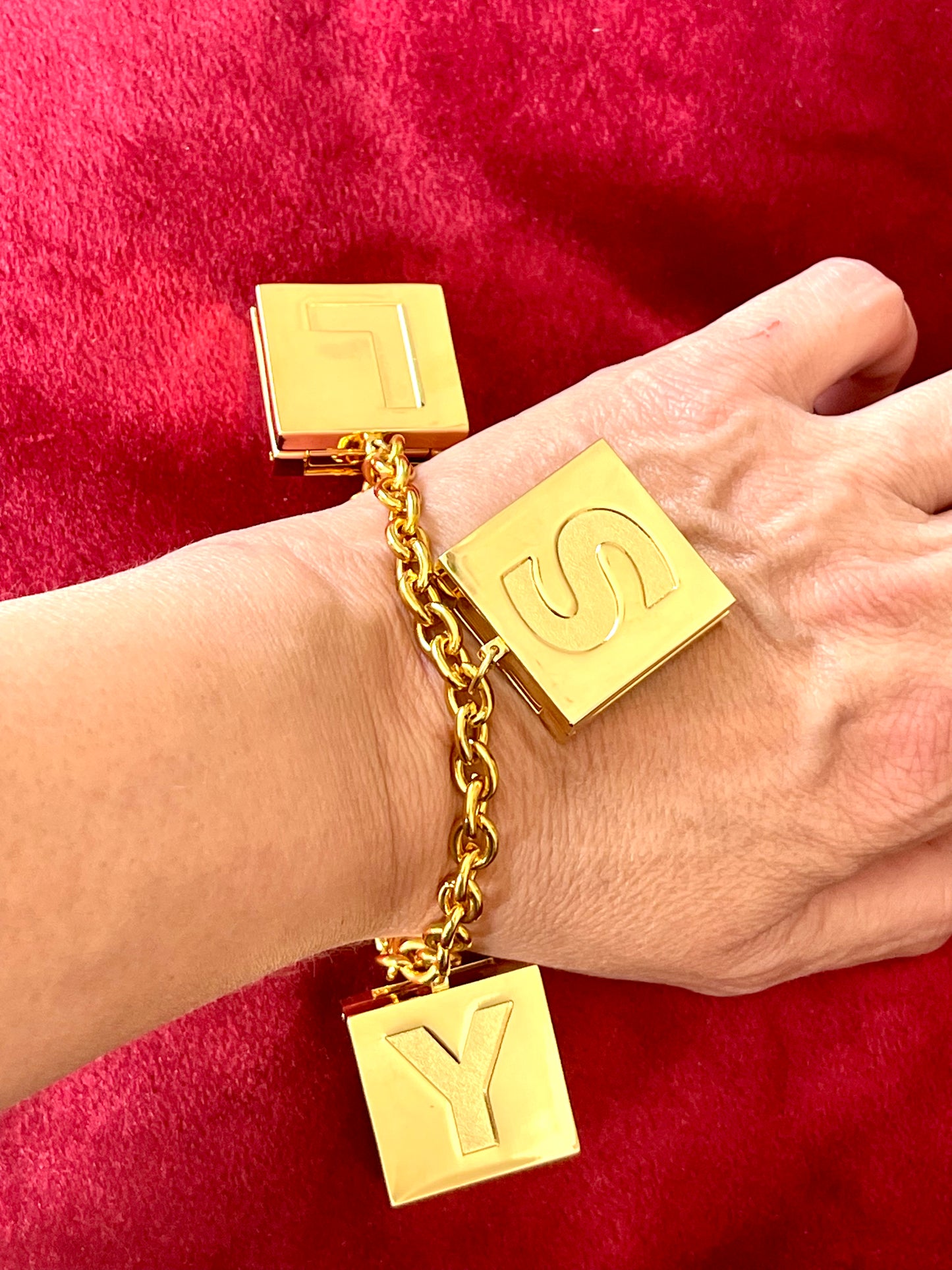 Worn on hand YSL Yves Saint Laurent vintage 2000 makeup bracelet very good condition on red velvet background