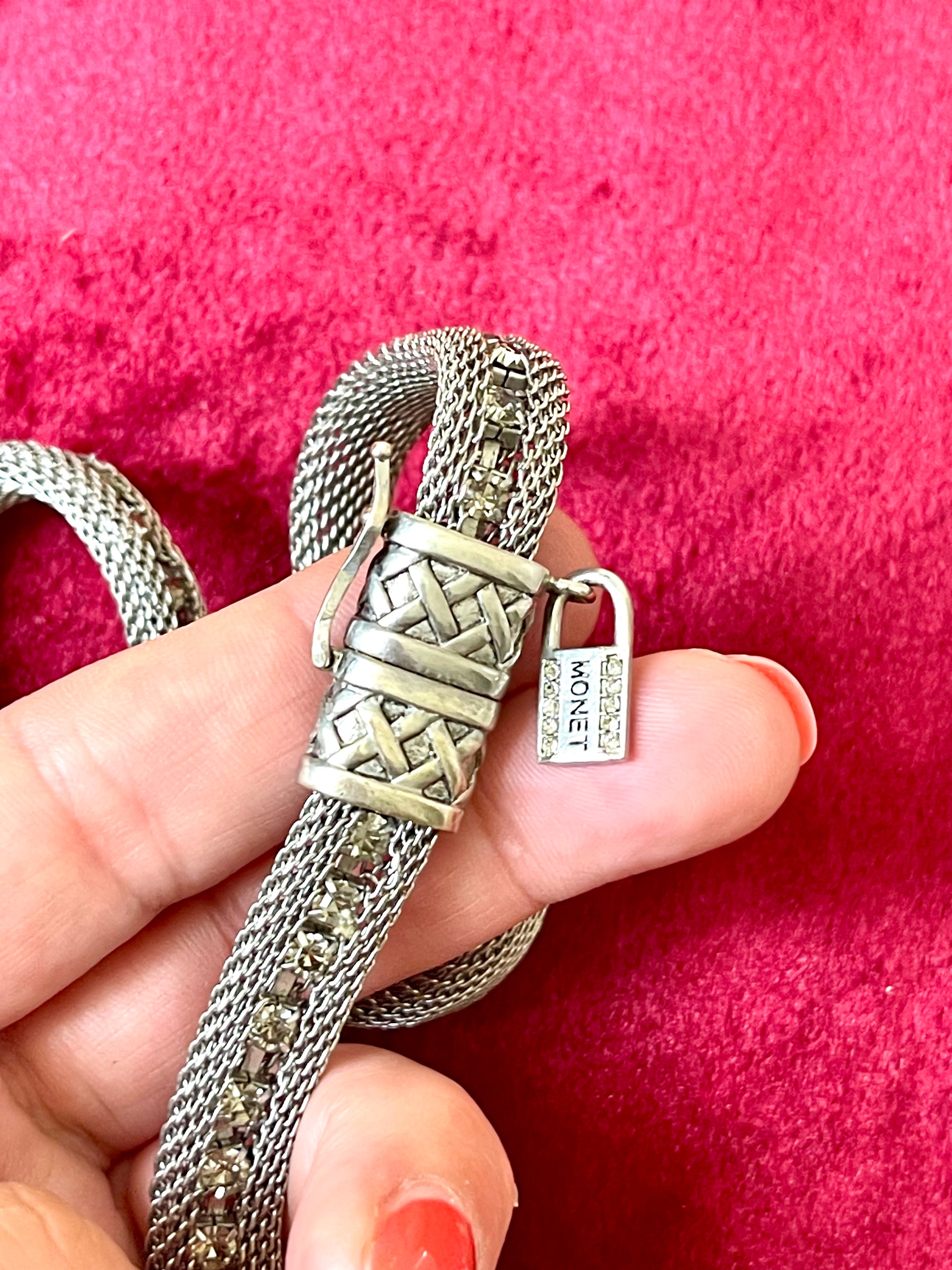 Close up on authentication tag Monet Yves Saint Laurent silver metal necklace rhinestone tagged chocker