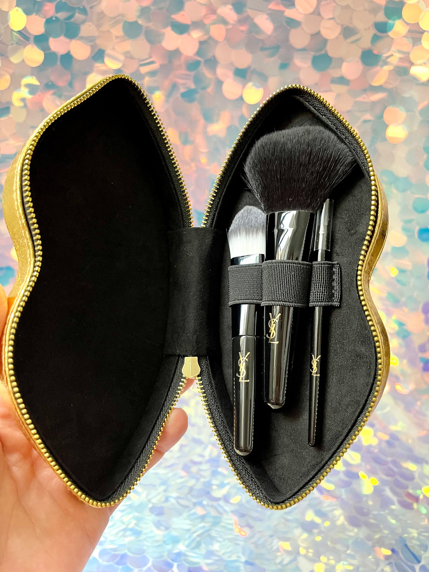 Inside view showing three accessories Yves Saint Laurent makeup brushes vanity - gold lips design unused perfect condition on sequins background YSL