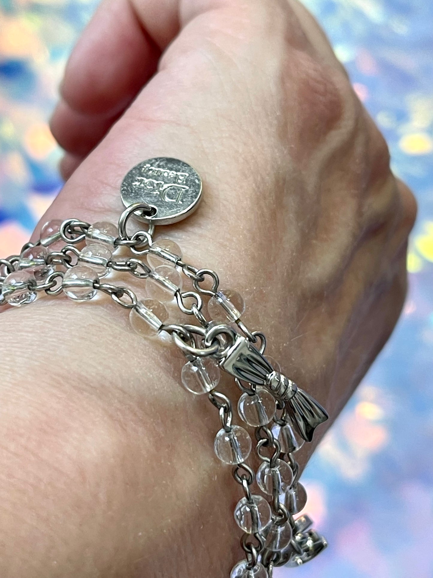 Close-up of vintage Dior Parfums bracelet, steel metal with crystal beads and silver-tone charms, highlighting intricate design and pristine vintage condition