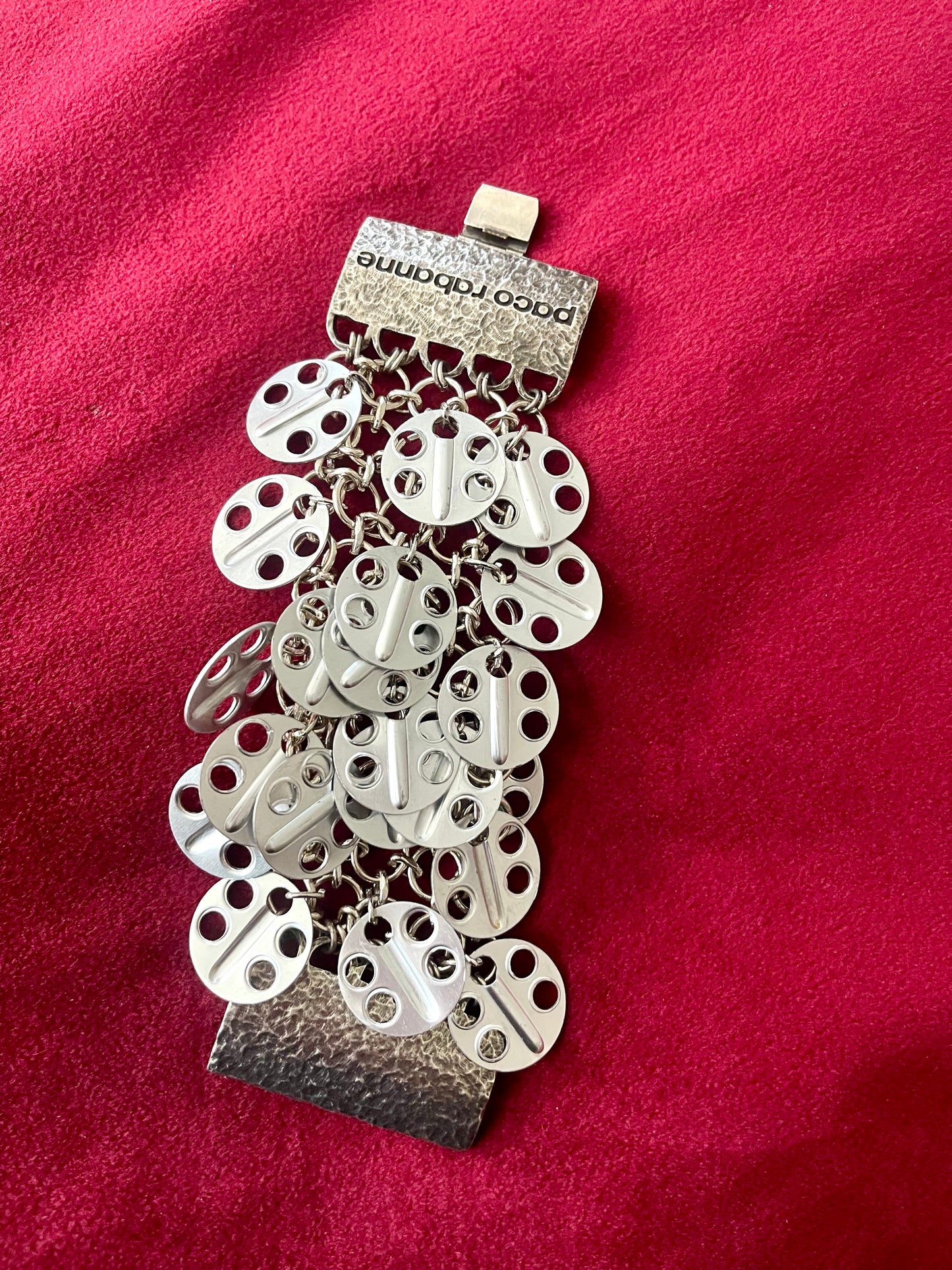 Full view Paco Rabanne silver-tone statement bracelet details on a red velvet background 