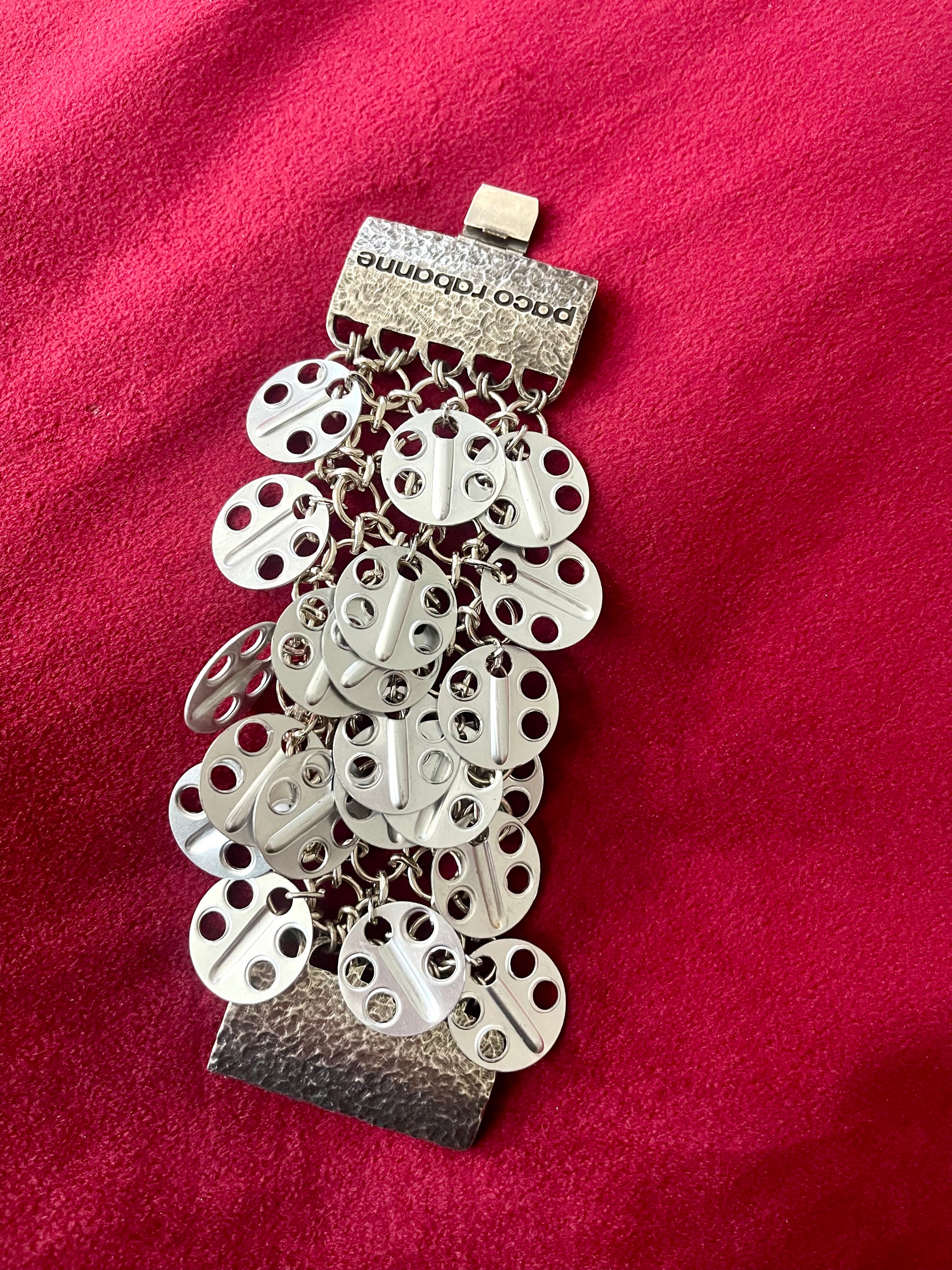 Full view Paco Rabanne silver-tone statement bracelet details on a red velvet background 