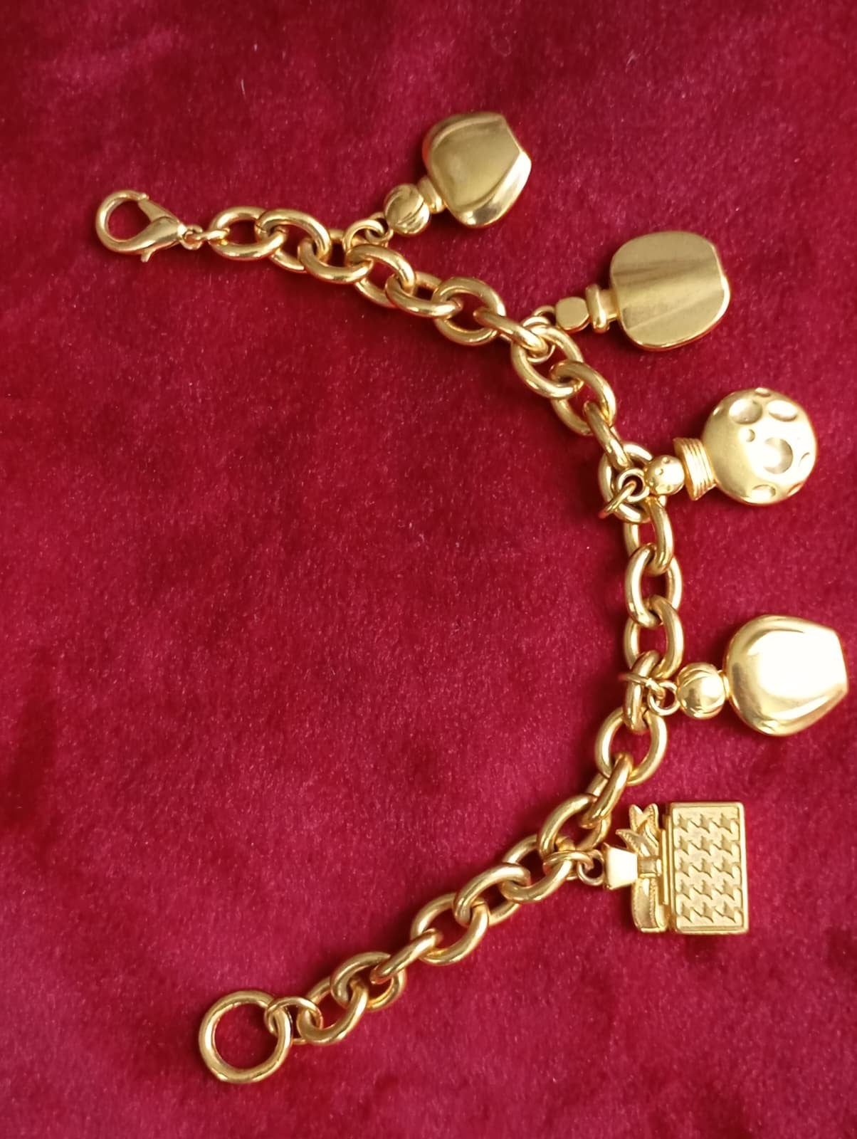 Vintage Dior bracelet on red background showing all charms