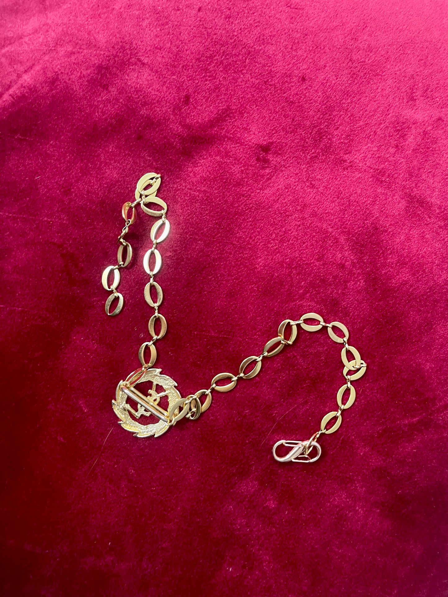 Back side view of a refurbished vintage YSL laurel wreath pendant mounted on a gold-plated stainless steel necklace, with adjustable hoop links and a slightly lighter-toned closure.