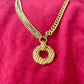 Gold tone 80s Yves Saint Laurent vintage pendant  stainless steel chain necklace  on red velvet background 