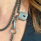 Worn by model close up on Vintage Saint Laurent upcycled necklace featuring a dark gunmetal chain with original lock and key charm pendant, repurposed from a Saint Laurent keychain