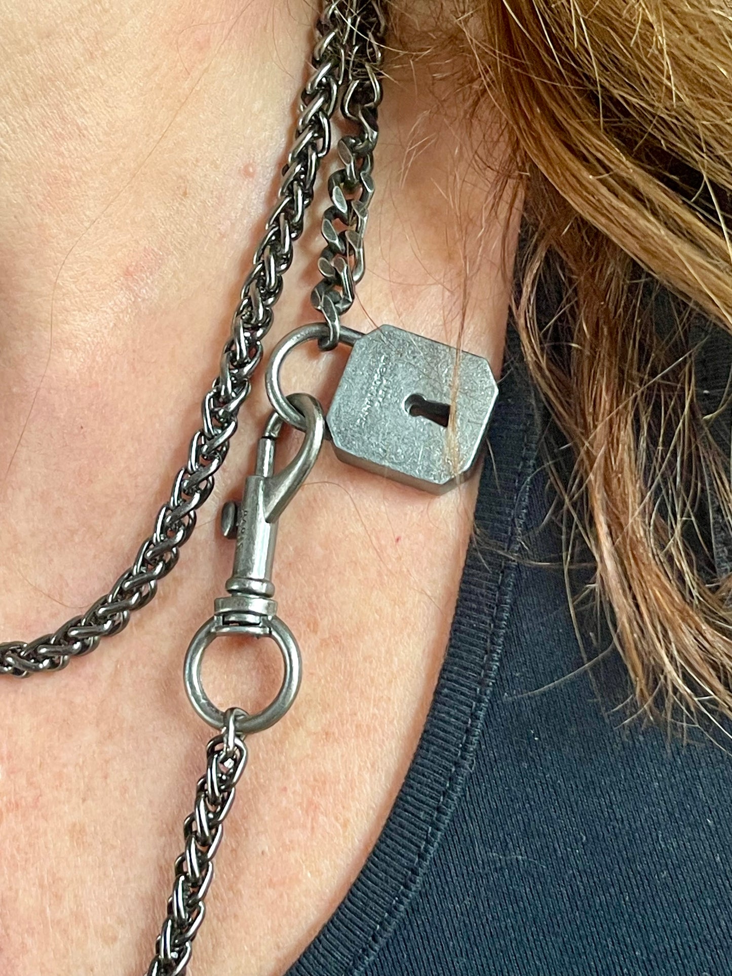 Worn by model close up on Vintage Saint Laurent upcycled necklace featuring a dark gunmetal chain with original lock and key charm pendant, repurposed from a Saint Laurent keychain