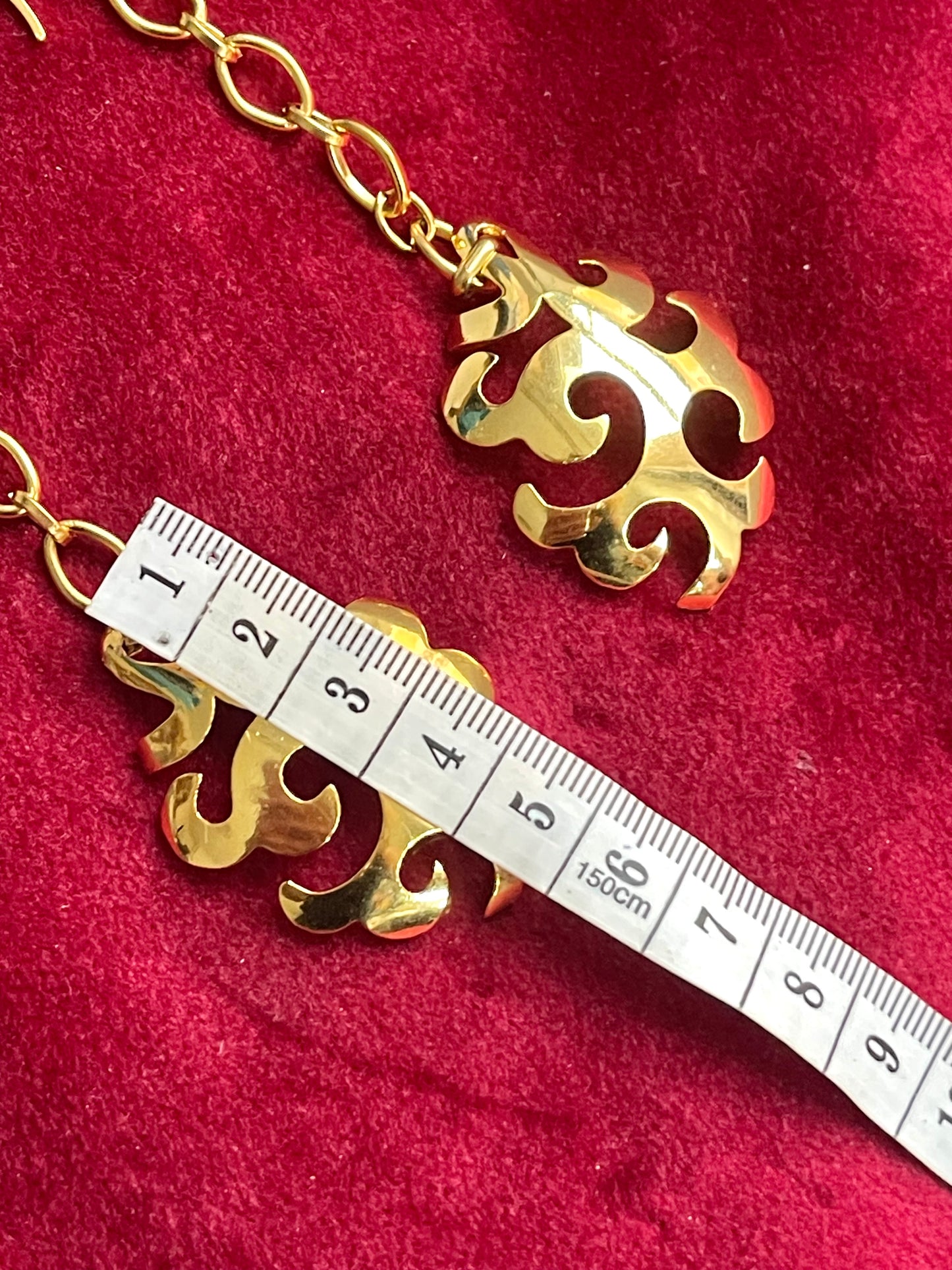 Vintage YSL statement pendant earrings showing length using a measuring tape 